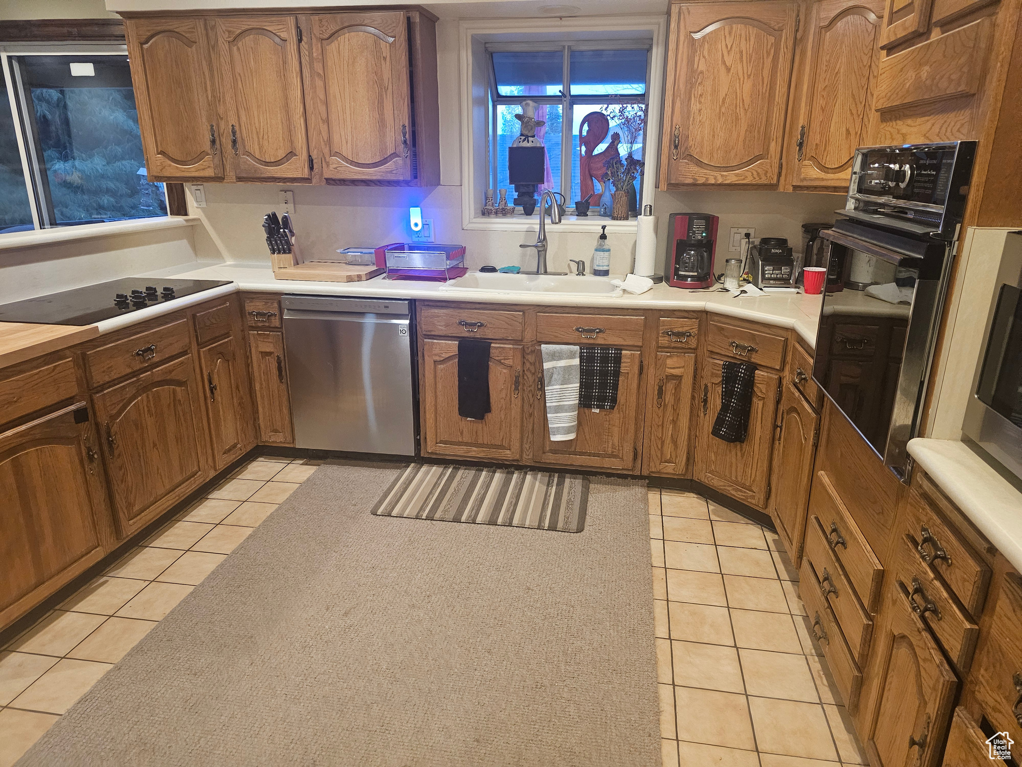 Kitchen with sink, light tile flooring, and black appliances