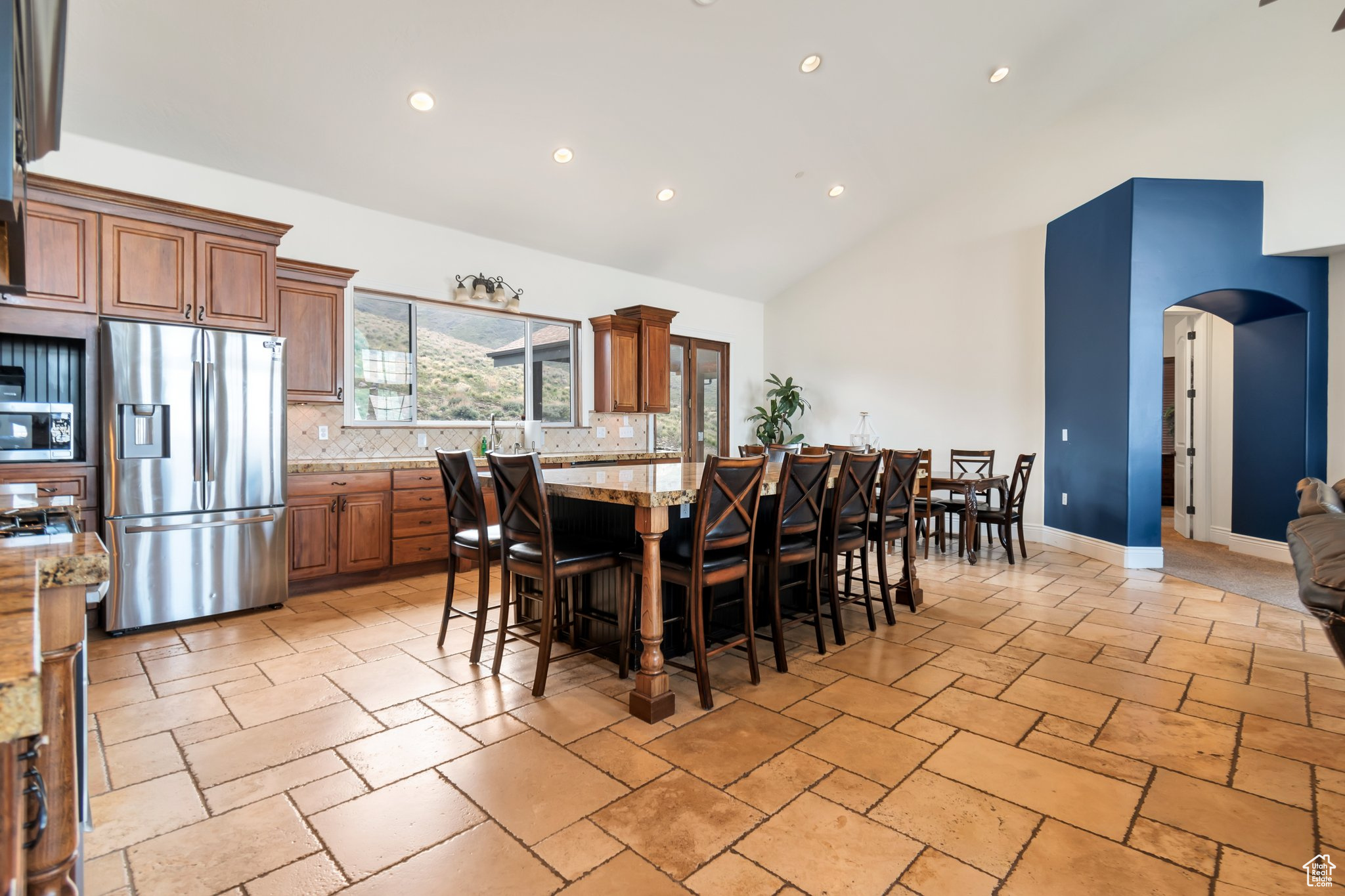 Dining space with high vaulted ceiling and light tile flooring