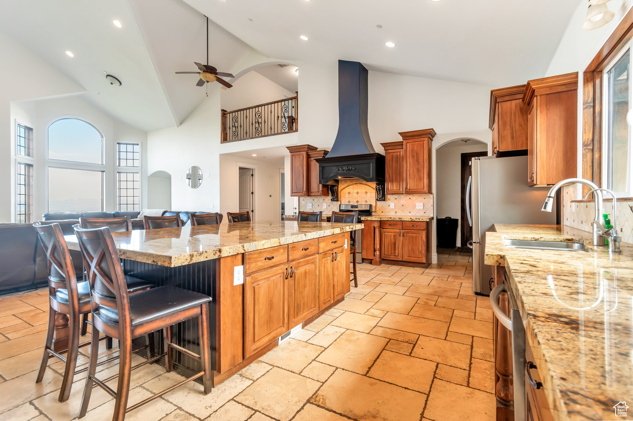 Kitchen featuring a center island, tasteful backsplash, premium range hood, and high vaulted ceiling