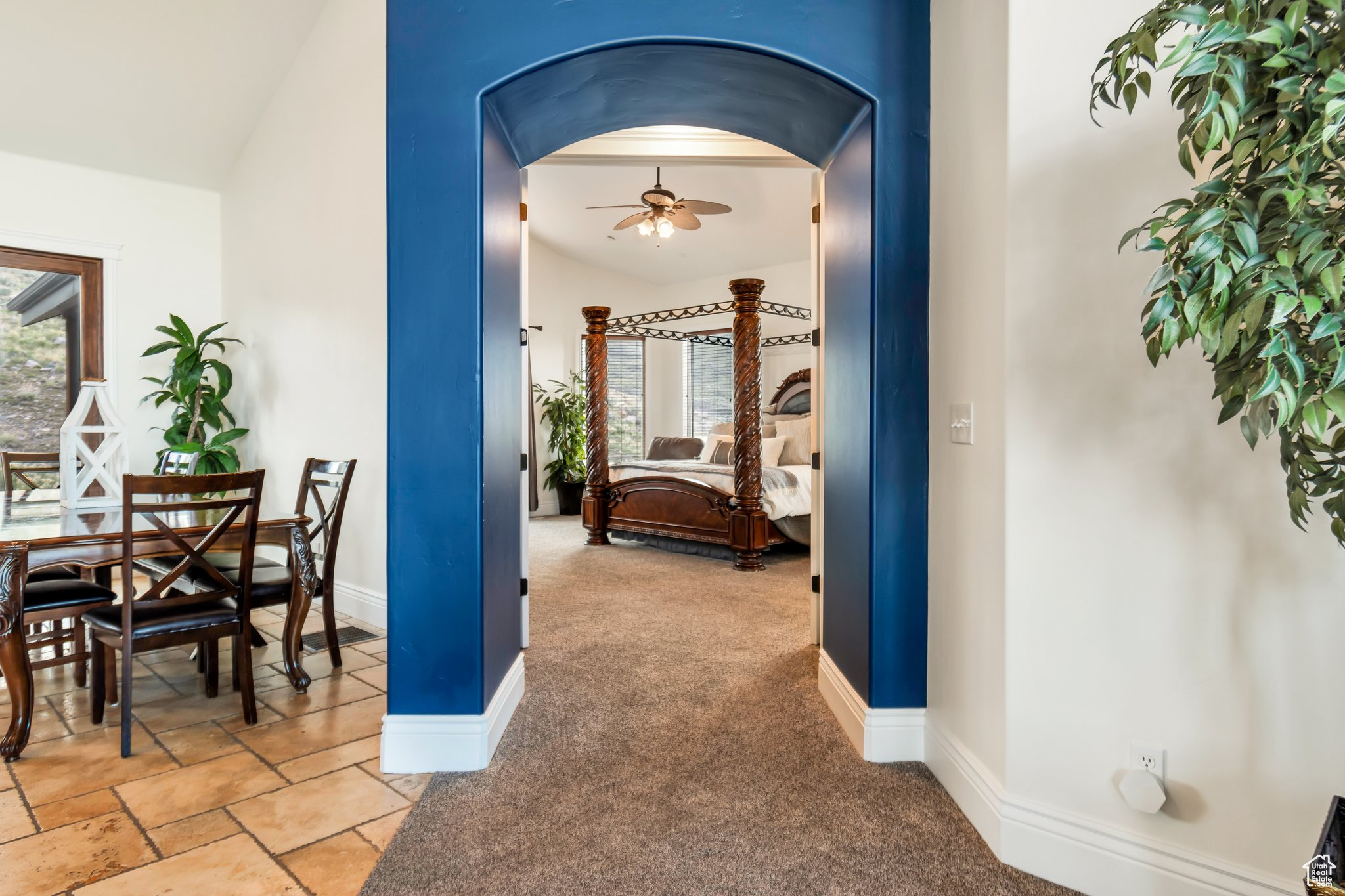 Hallway featuring tile flooring and vaulted ceiling