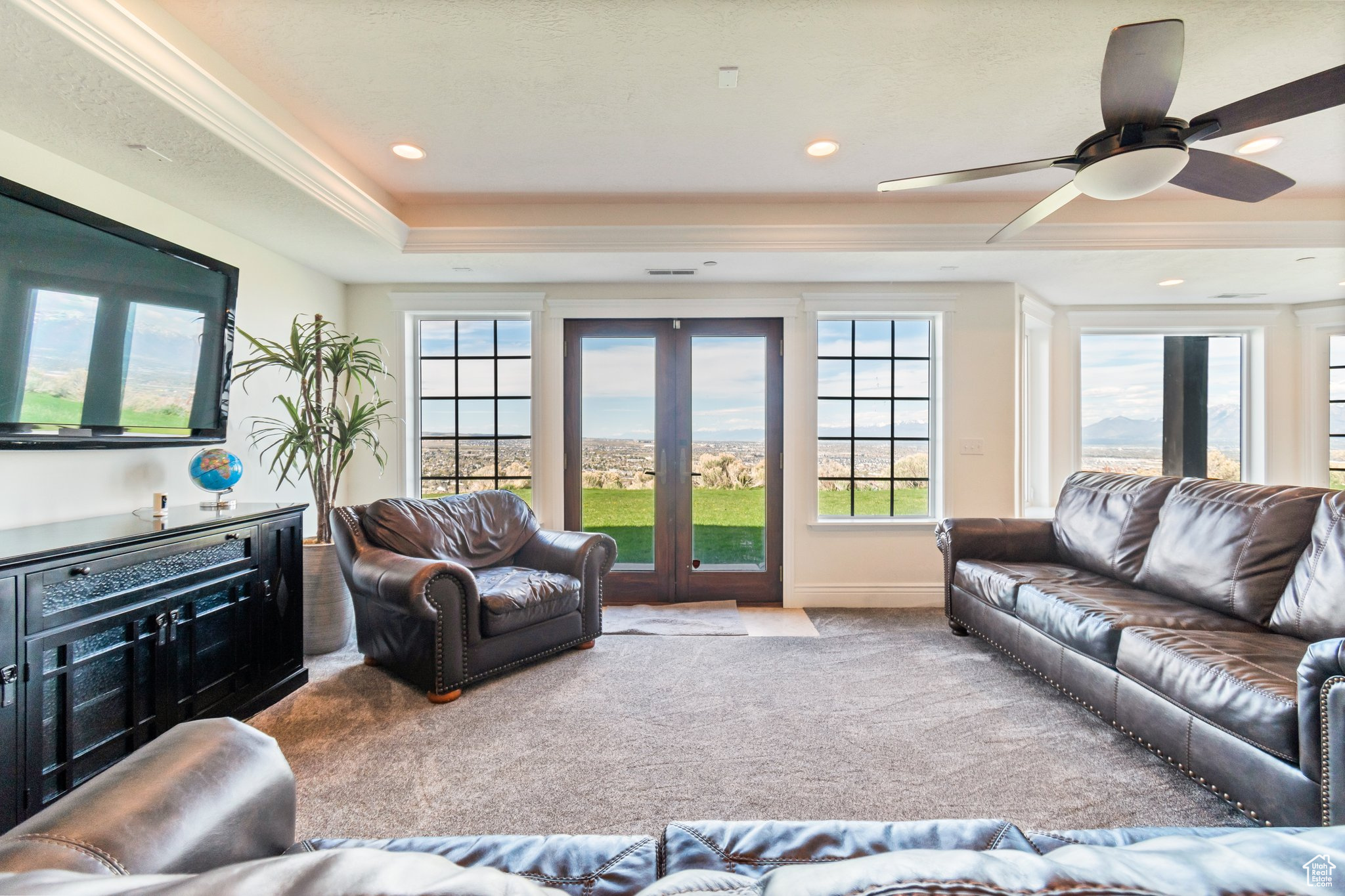 Living room with french doors, ceiling fan, a tray ceiling, carpet, and ornamental molding
