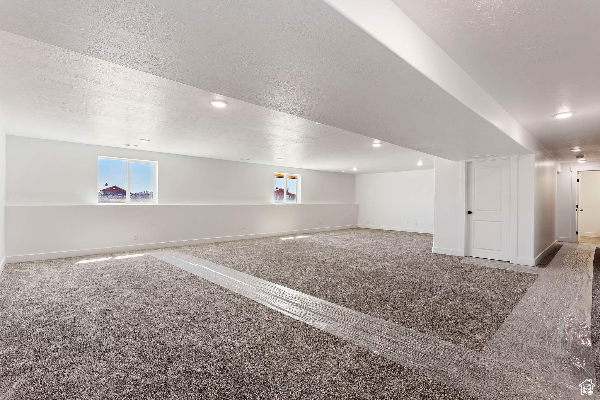 Basement with a textured ceiling and carpet flooring