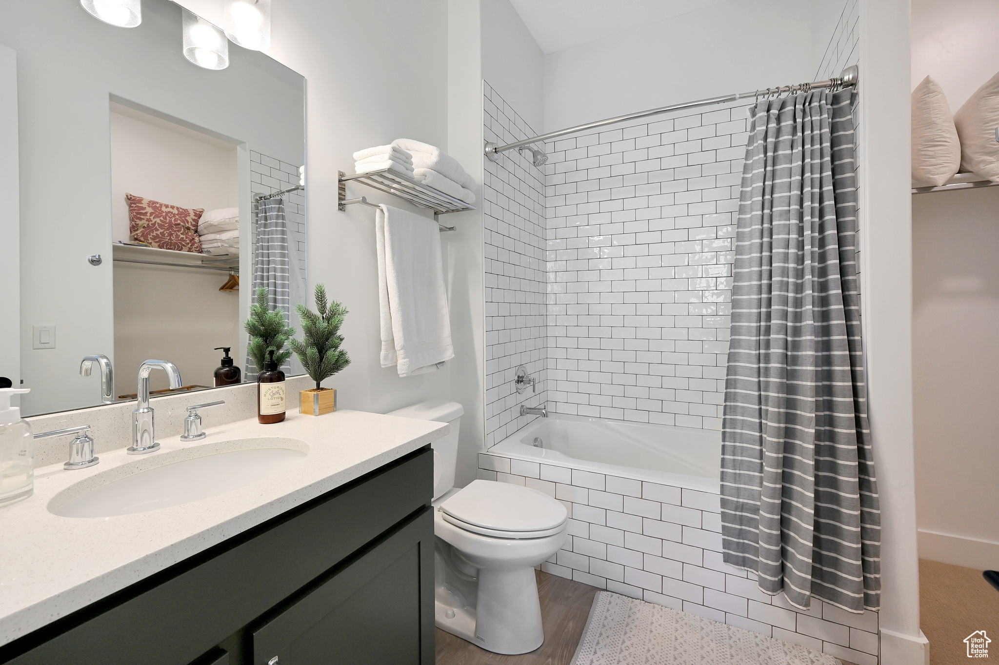 Full bathroom with shower / tub combo with curtain, hardwood / wood-style flooring, vanity, and toilet