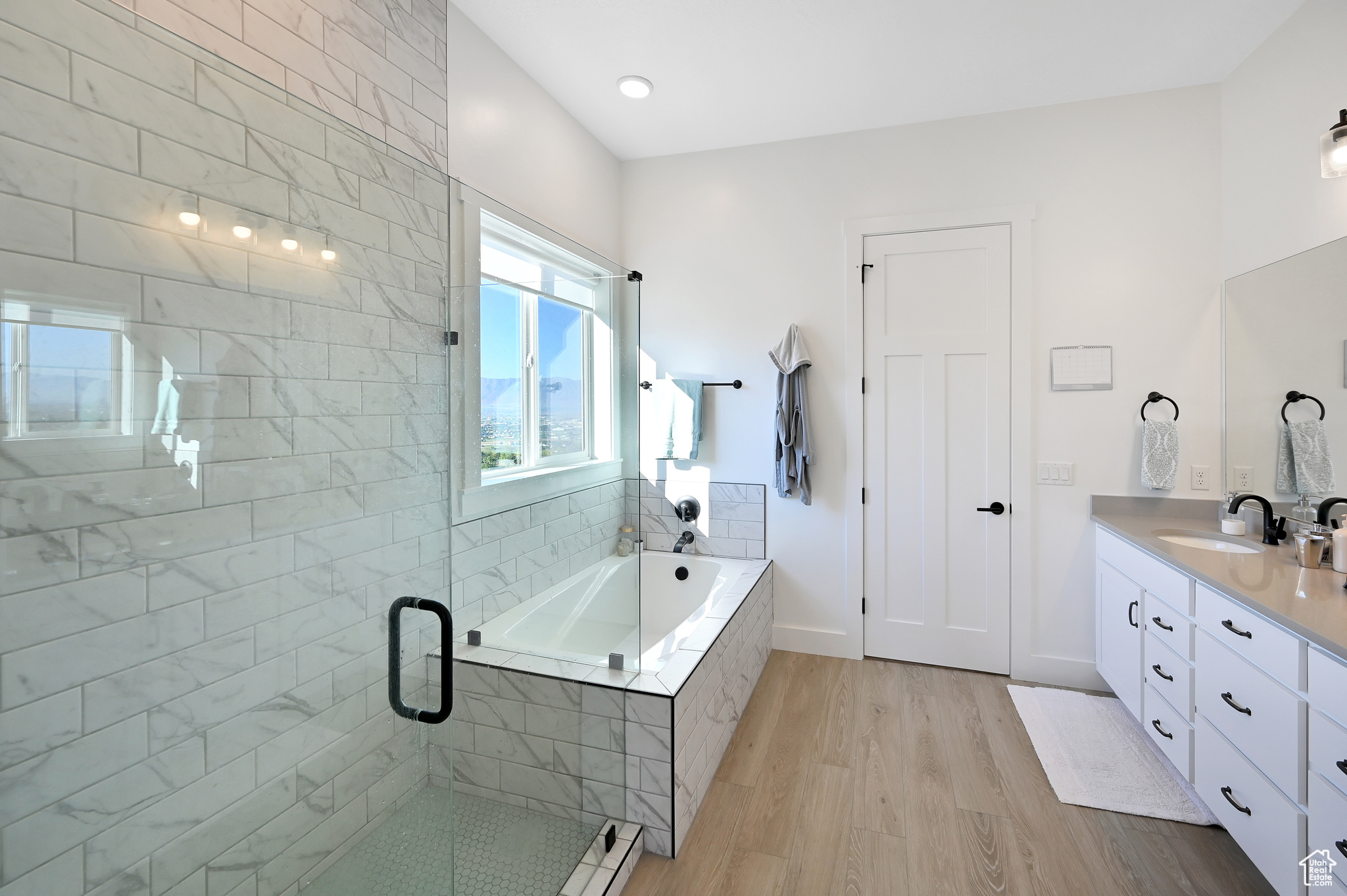 Bathroom featuring plus walk in shower, hardwood / wood-style floors, and vanity