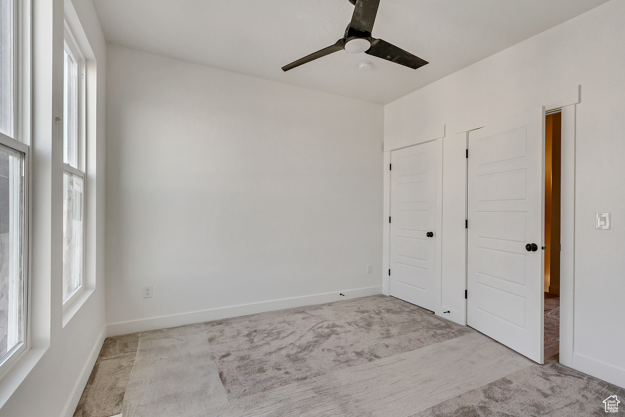 Empty room featuring light carpet and ceiling fan