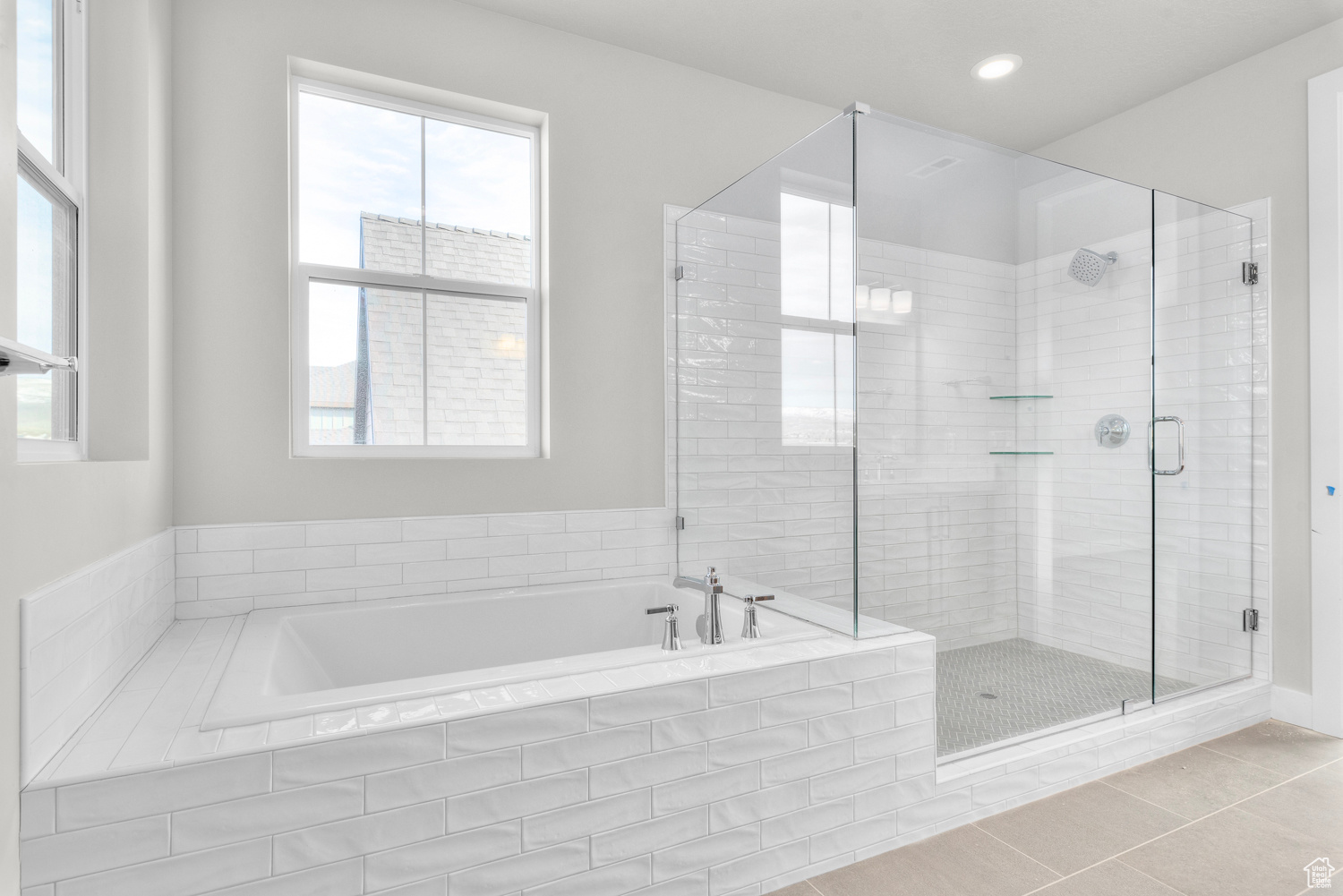 Bathroom featuring tile floors, a wealth of natural light, and plus walk in shower