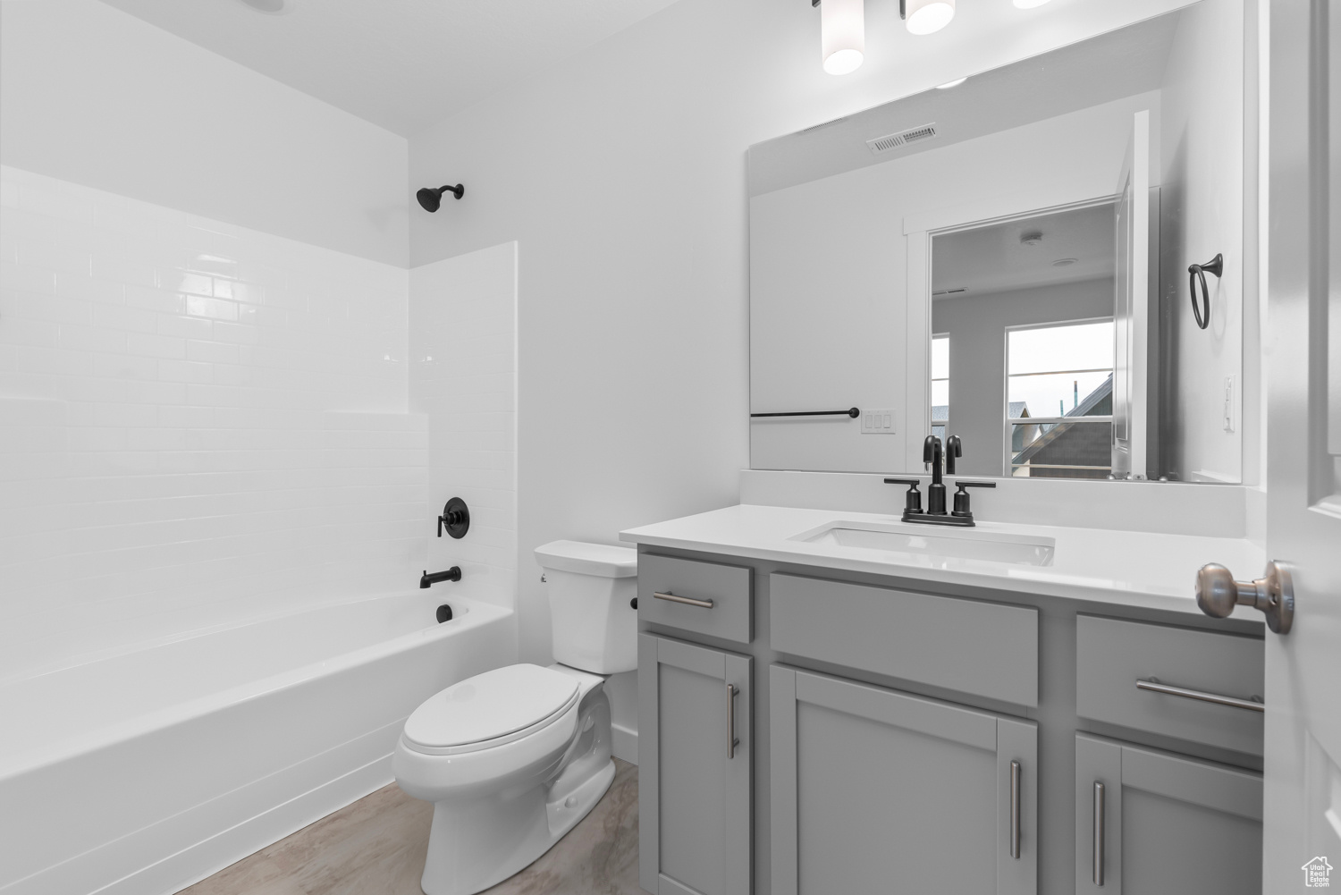 Full bathroom featuring tiled shower / bath combo, vanity, toilet, and hardwood / wood-style flooring