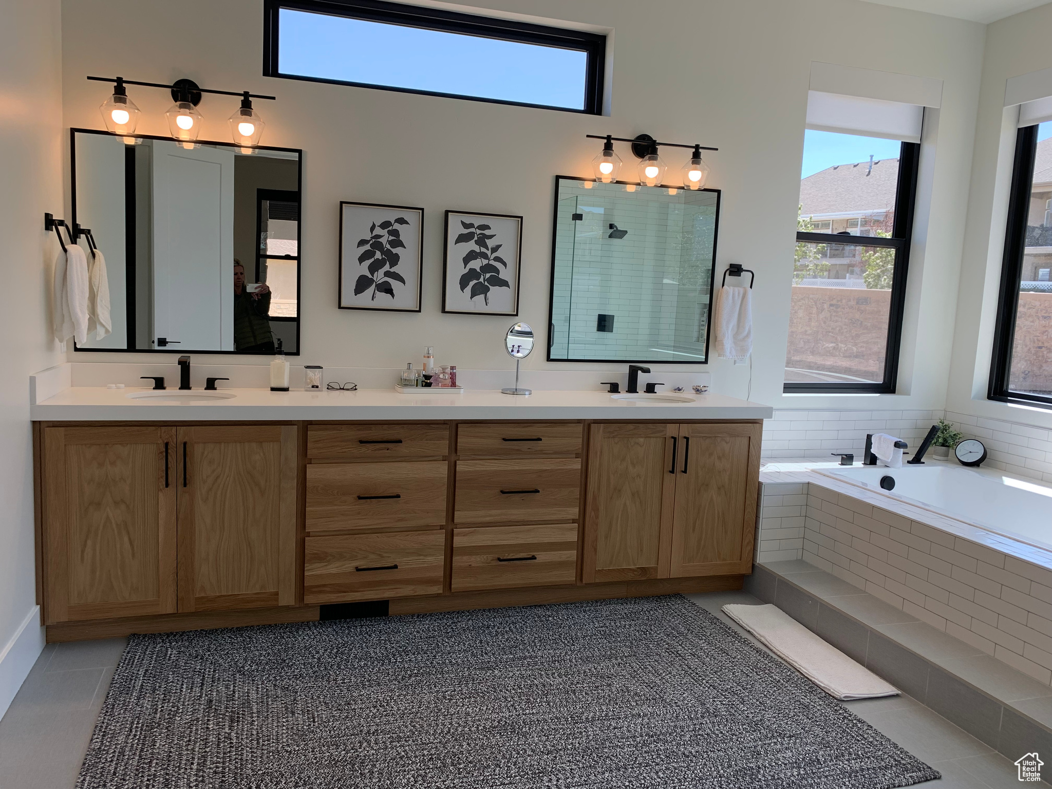 Bathroom with double vanity, tile floors, and tiled bath
