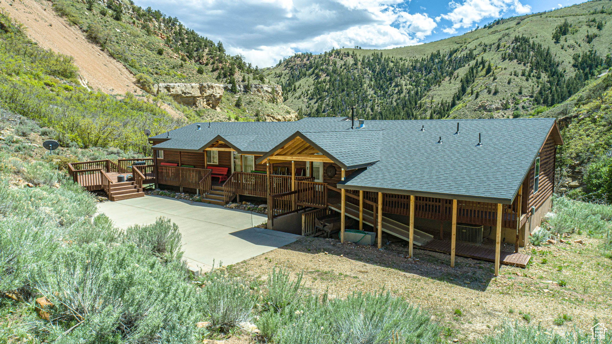 Back of property with central AC unit and a deck with mountain view