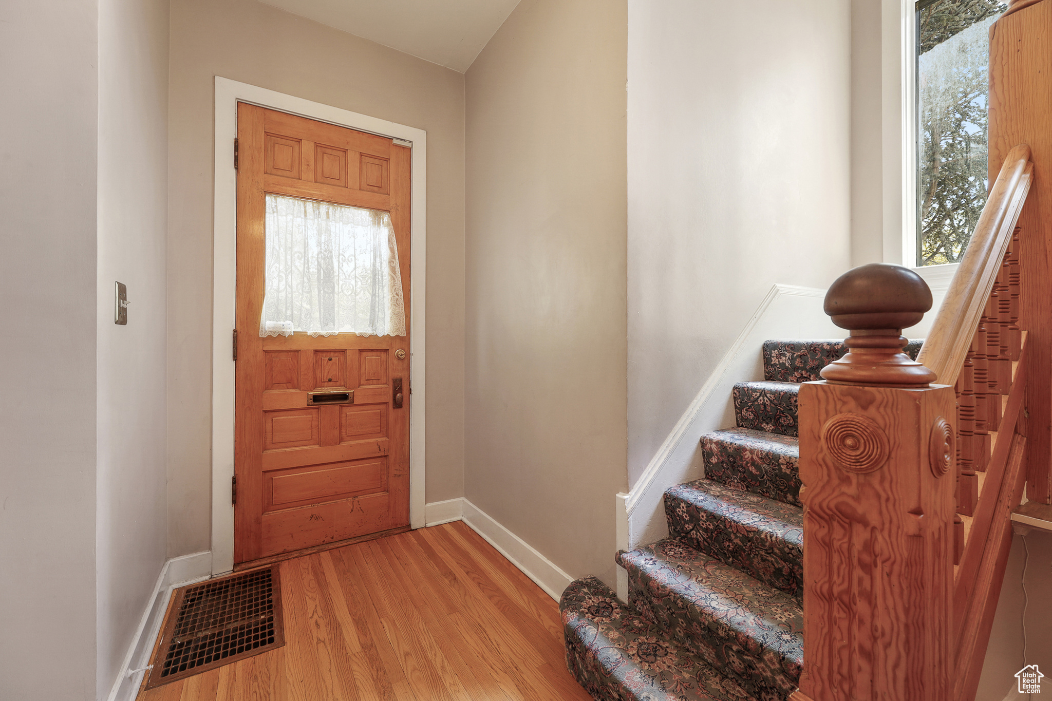 Entryway with original hardwood railings hardwood flooring
