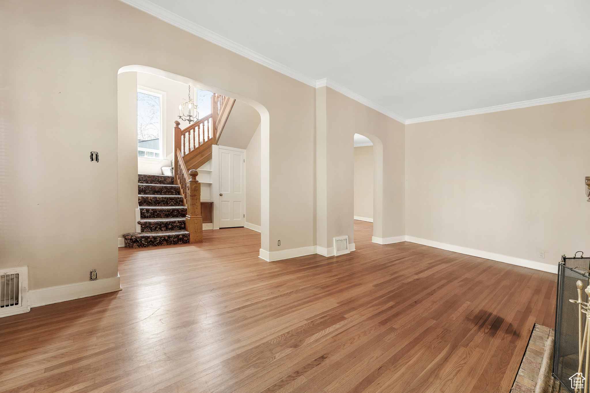 Interior space featuring a notable chandelier, crown molding, and hardwood / wood-style flooring