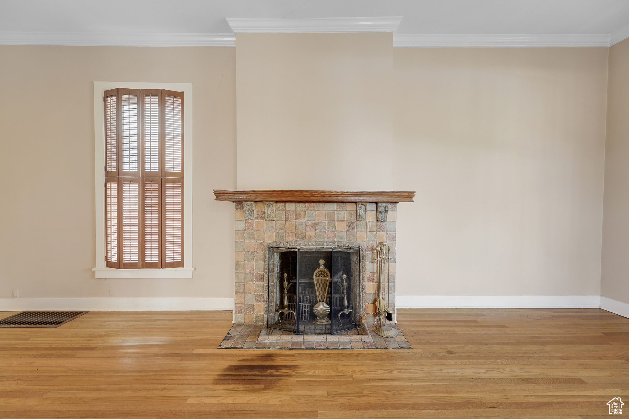Living room with ornamental molding and hardwood flooring with fireplace