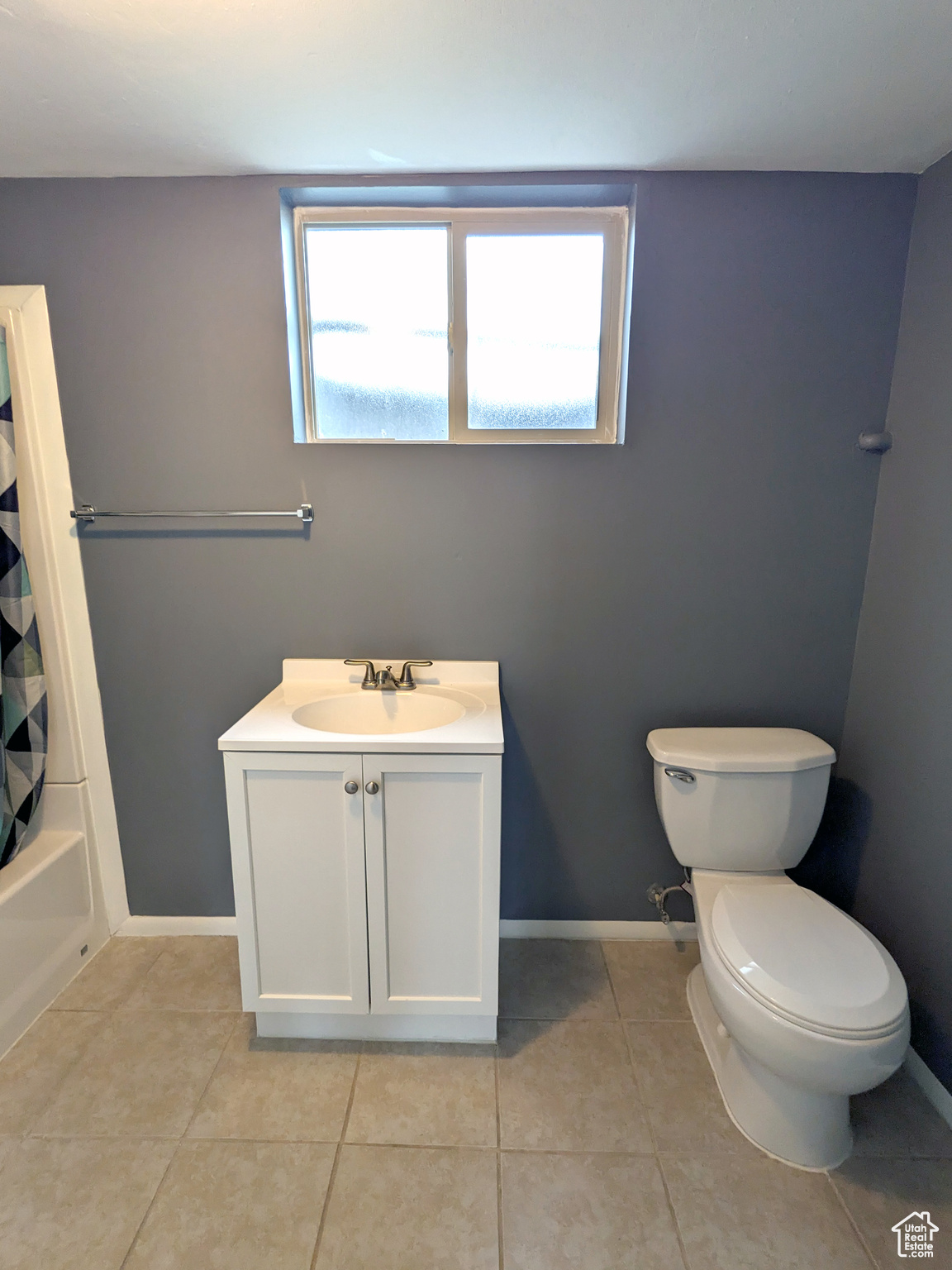 Full bathroom with shower / bathtub combination with curtain, toilet, tile floors, and vanity