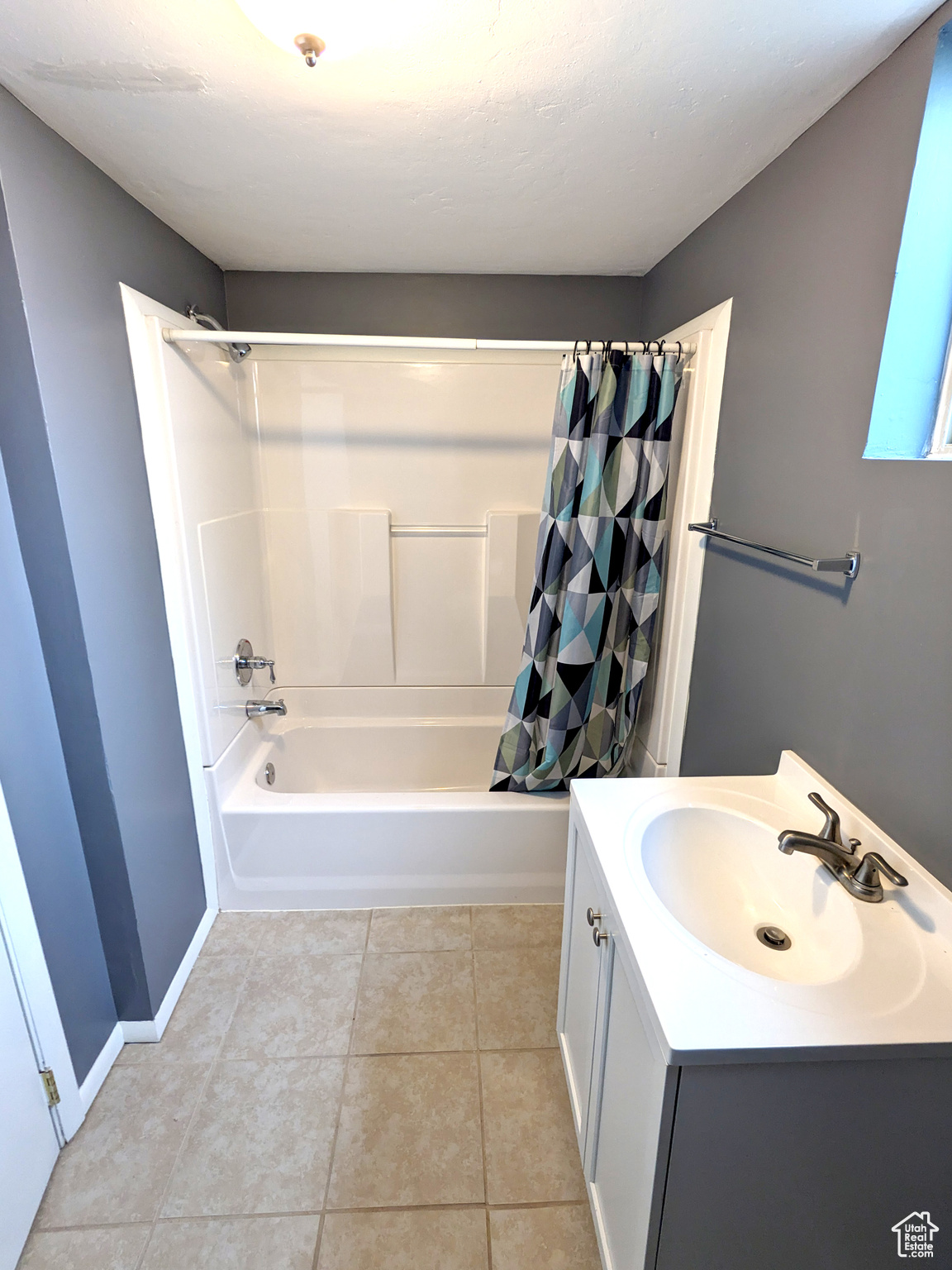 Bathroom featuring shower / bath combo, tile floors, and vanity
