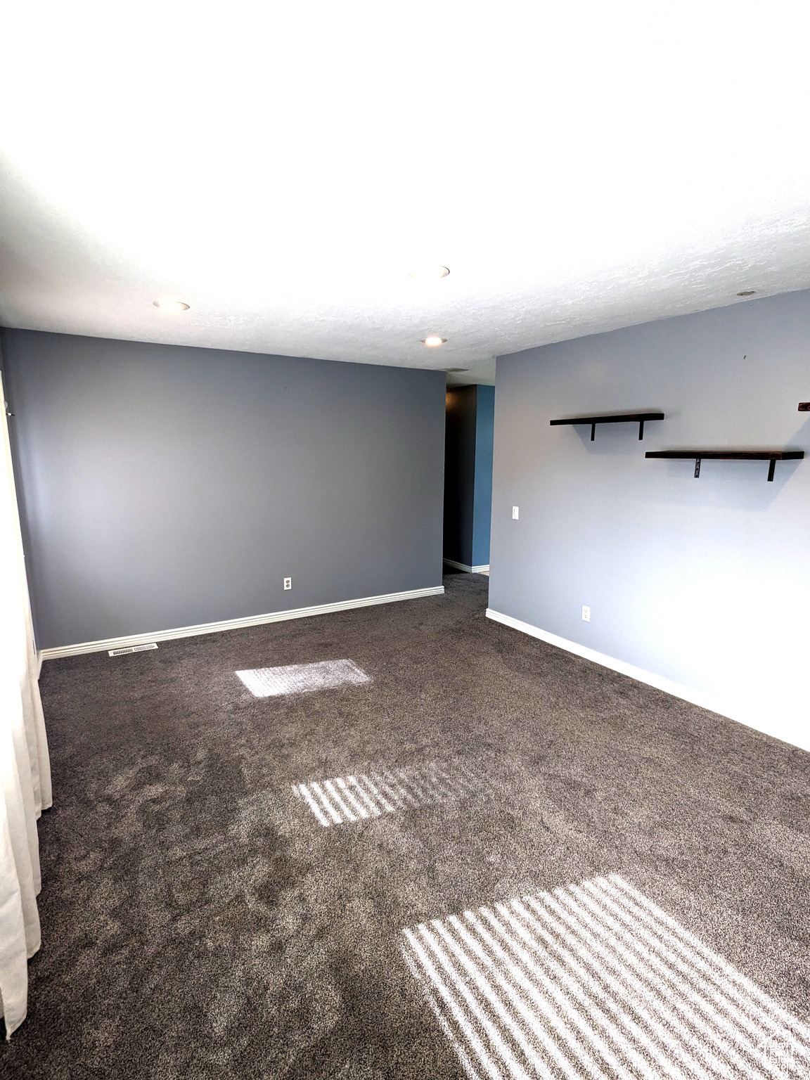 Empty room featuring dark colored carpet