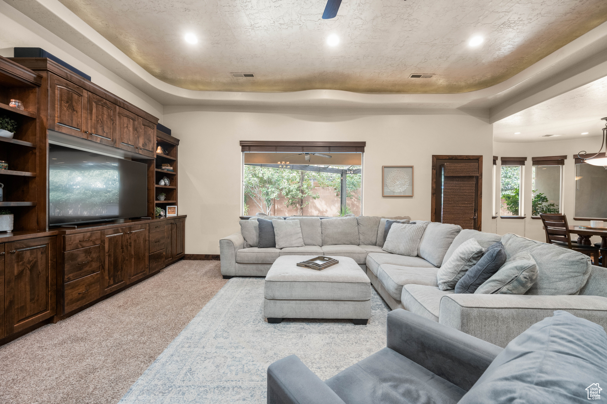 Living room featuring light colored carpet and a tray ceiling