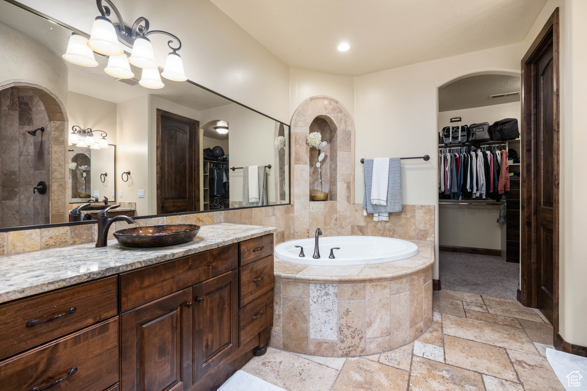 Bathroom with vanity, tile floors, and tiled tub