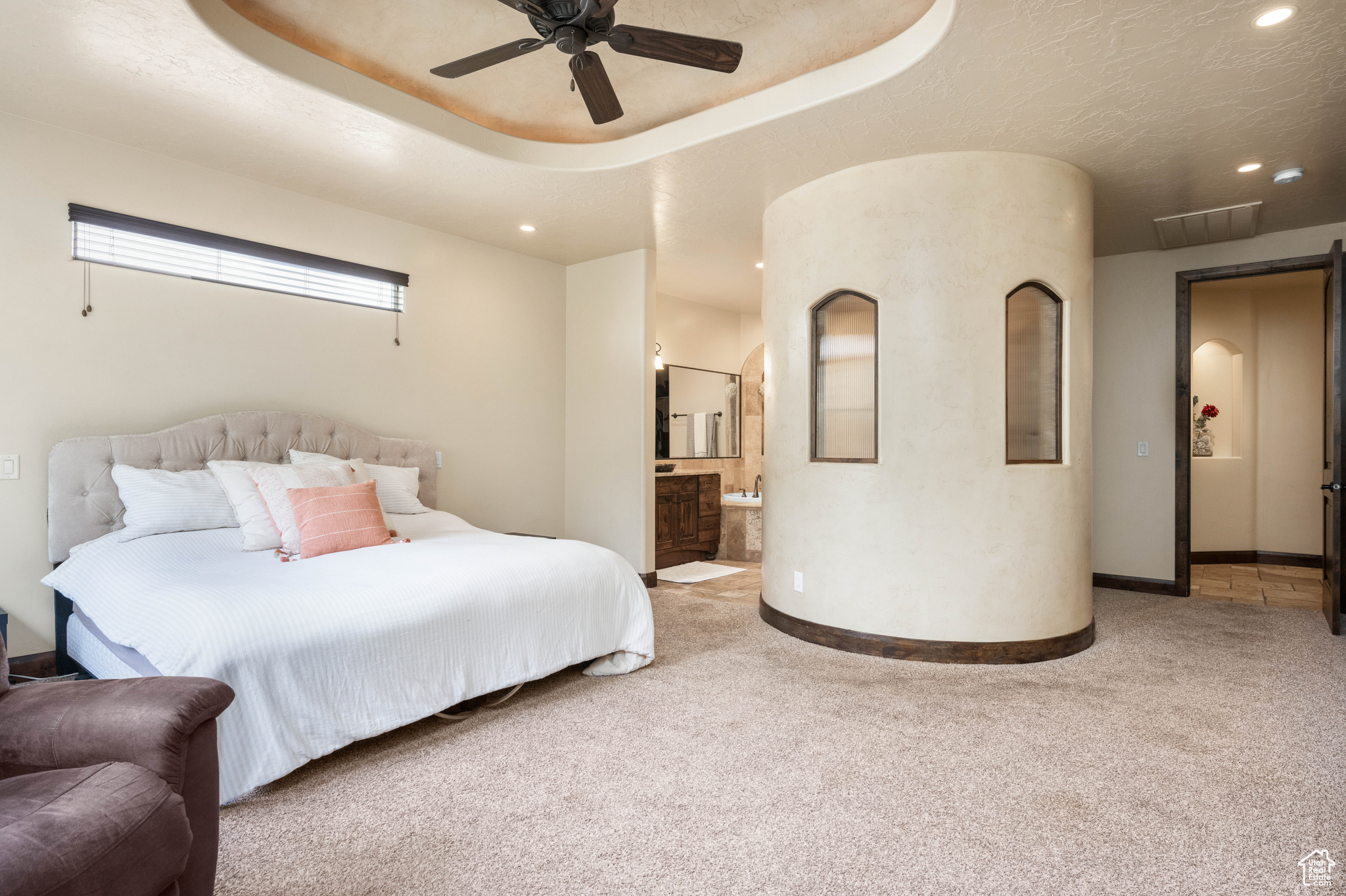 Bedroom with ceiling fan, connected bathroom, and carpet flooring