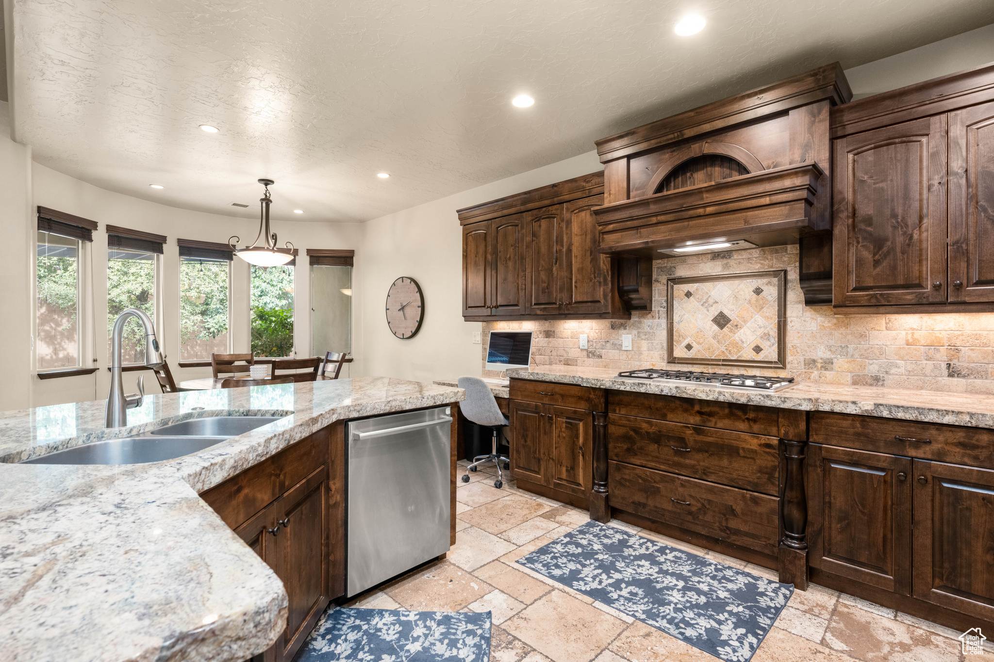 Kitchen with sink, tasteful backsplash, light tile flooring, stainless steel appliances, and pendant lighting