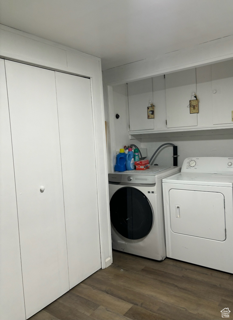 Laundry room with separate washer and dryer and dark wood-type flooring