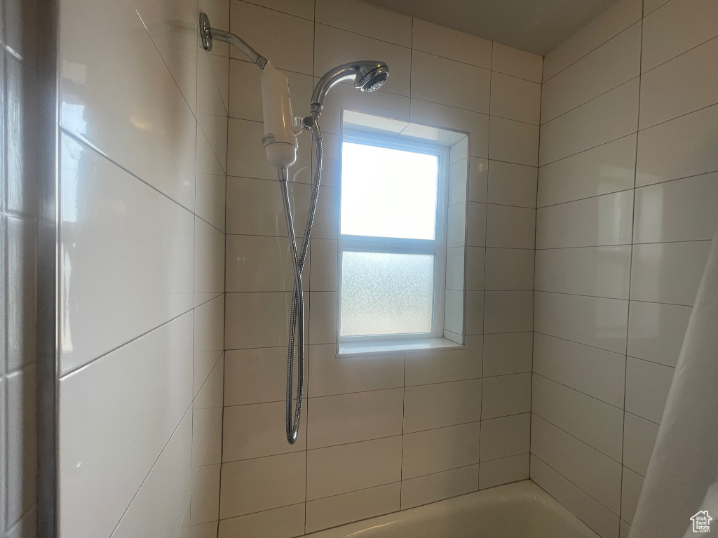 Bathroom with shower / bathtub combination with curtain