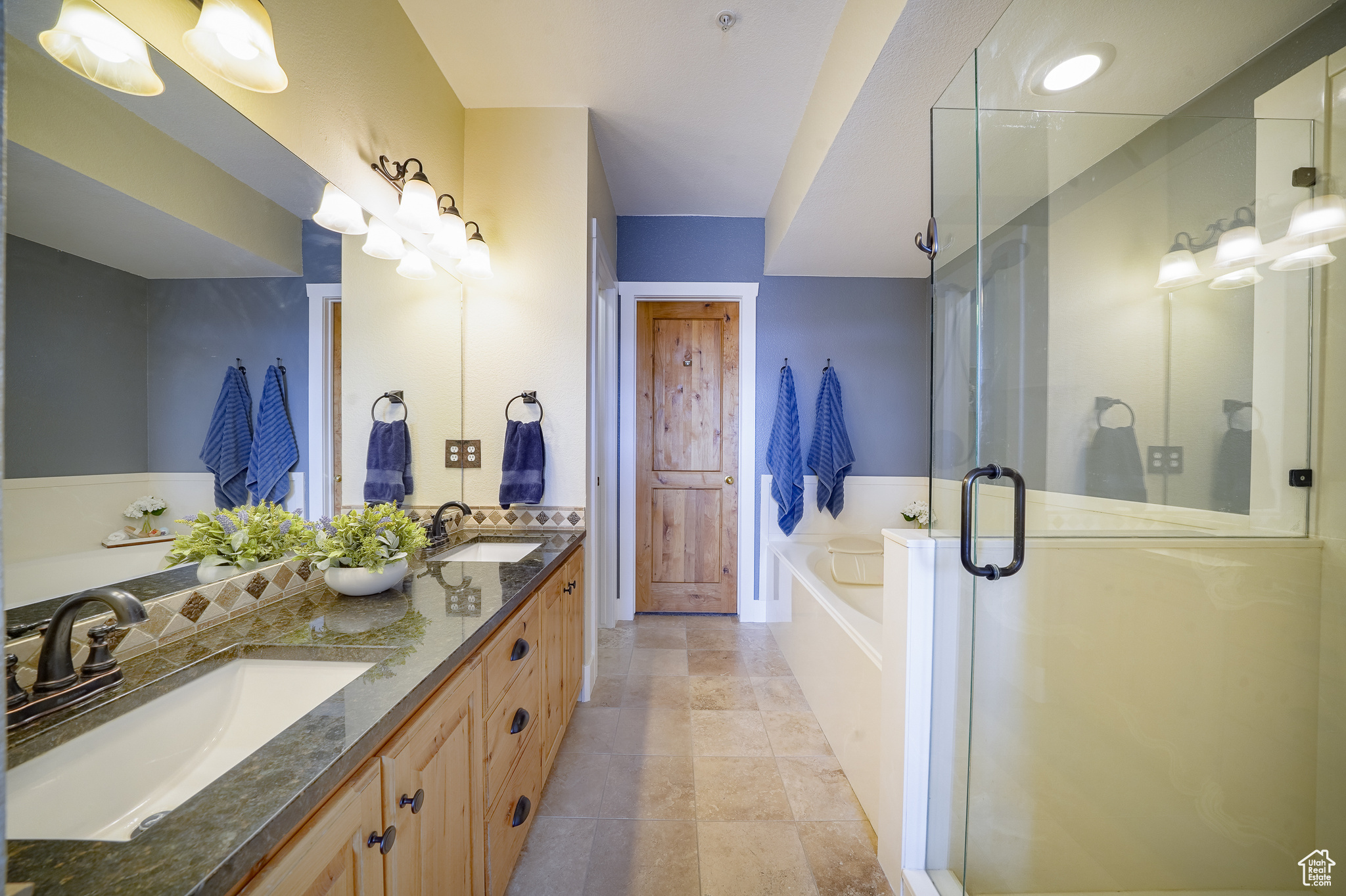 Bathroom with dual sinks, tile floors, independent shower and bath, and large vanity