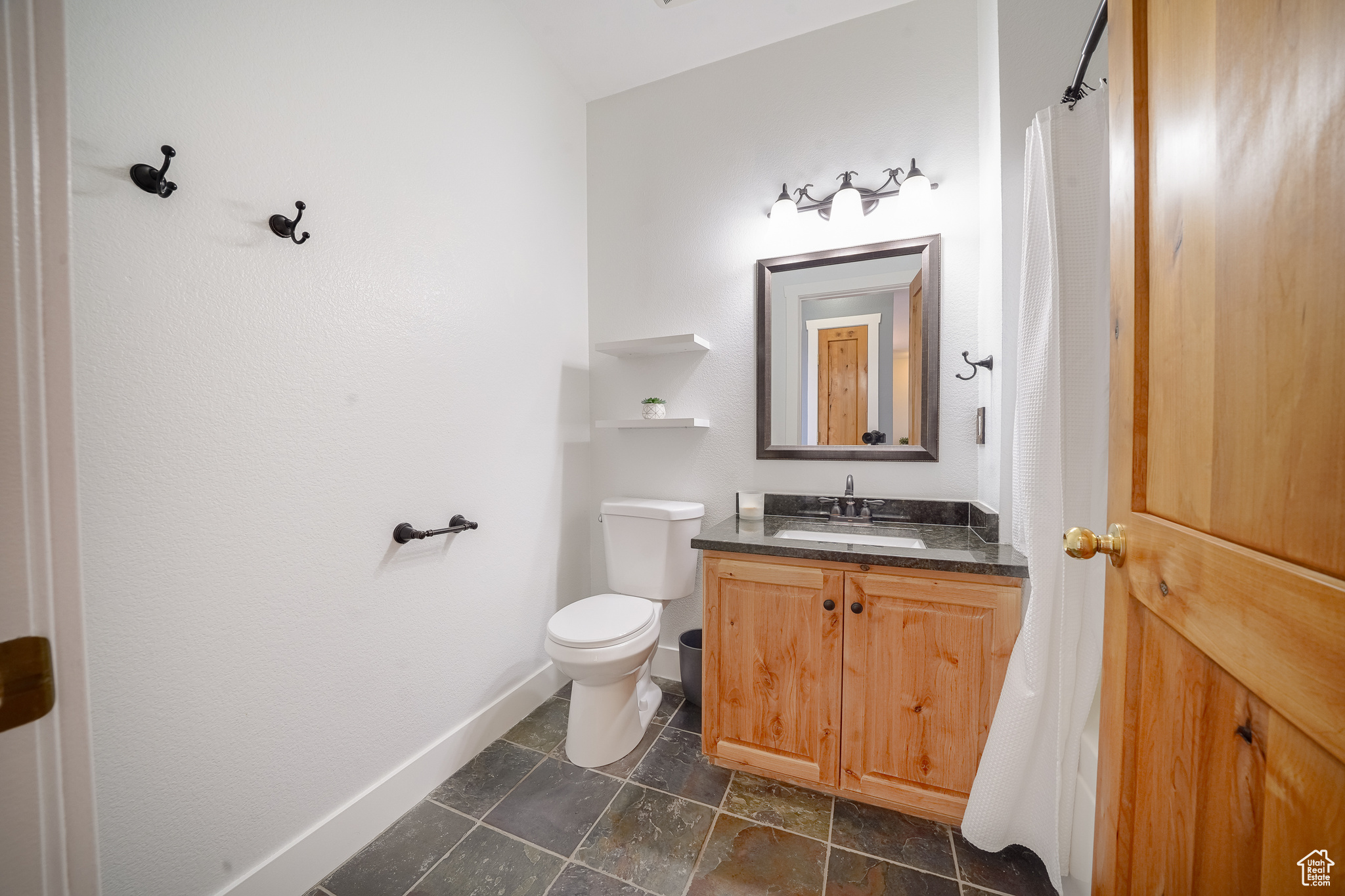 Bathroom featuring toilet, tile flooring, and large vanity