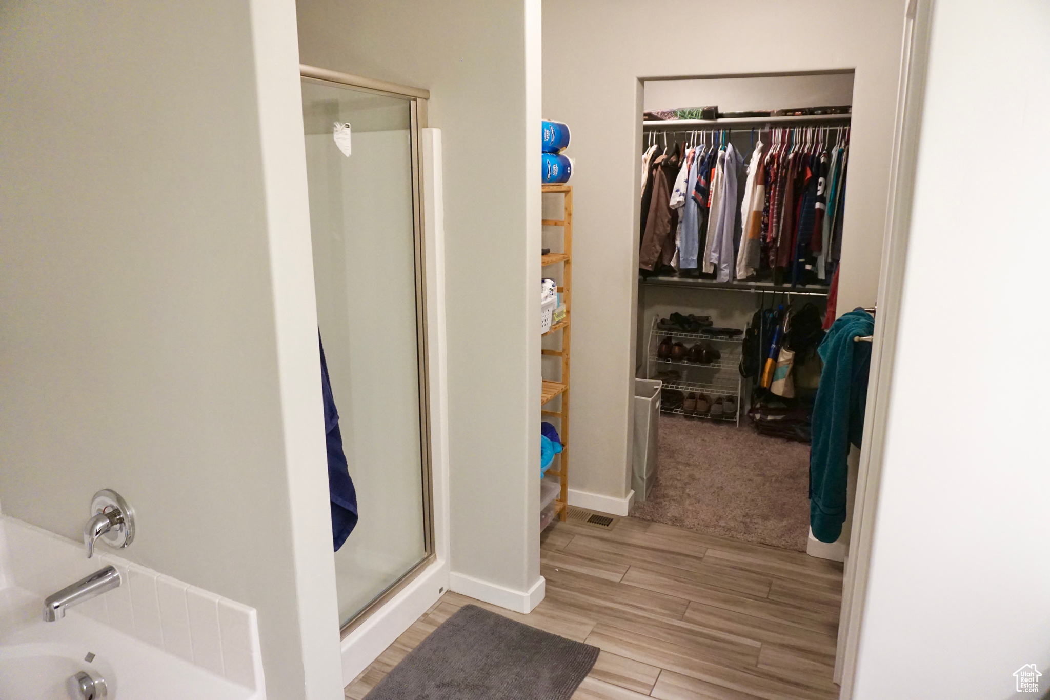 Primary bathroom featuring a shower, separate tub, and walk-in closet
