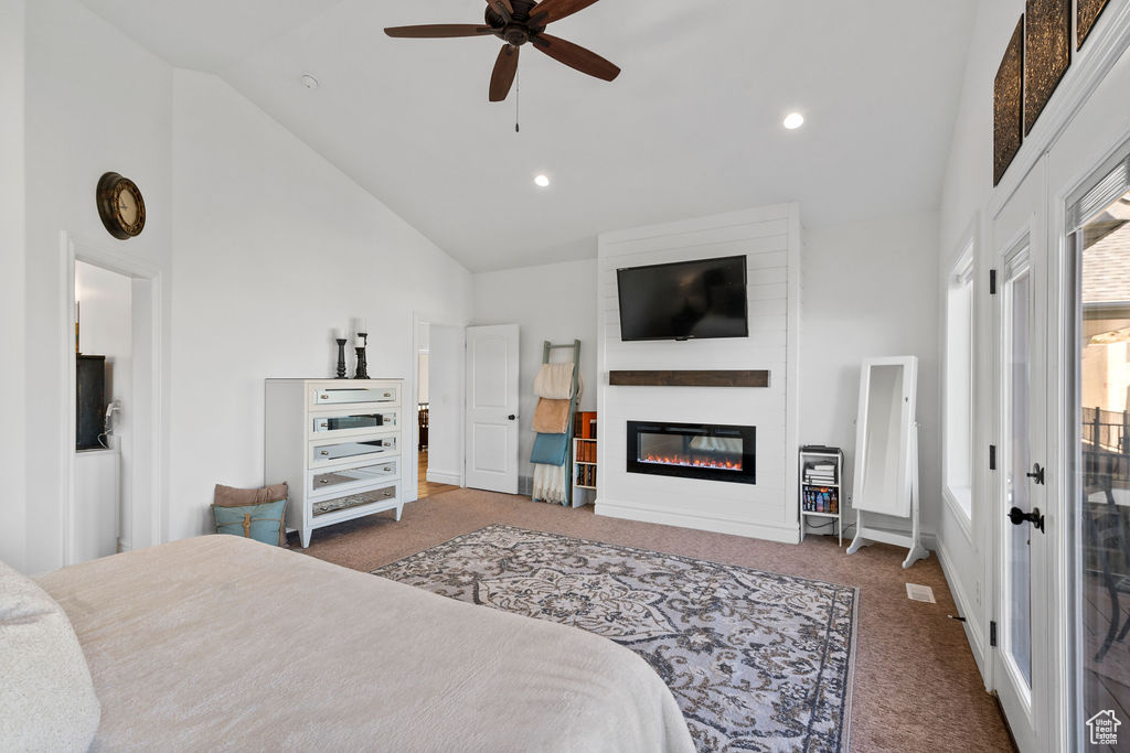 Carpeted bedroom with high vaulted ceiling, a large fireplace, and ceiling fan