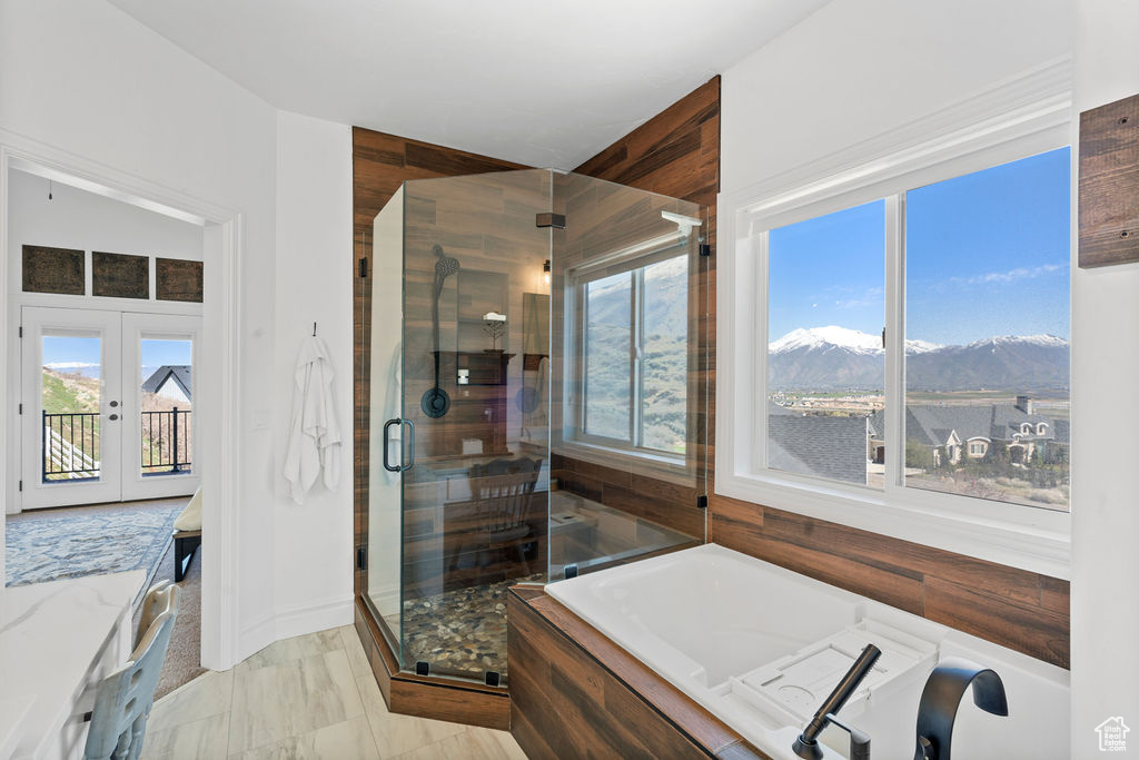 Bathroom featuring french doors, a mountain view, tile floors, and independent shower and bath
