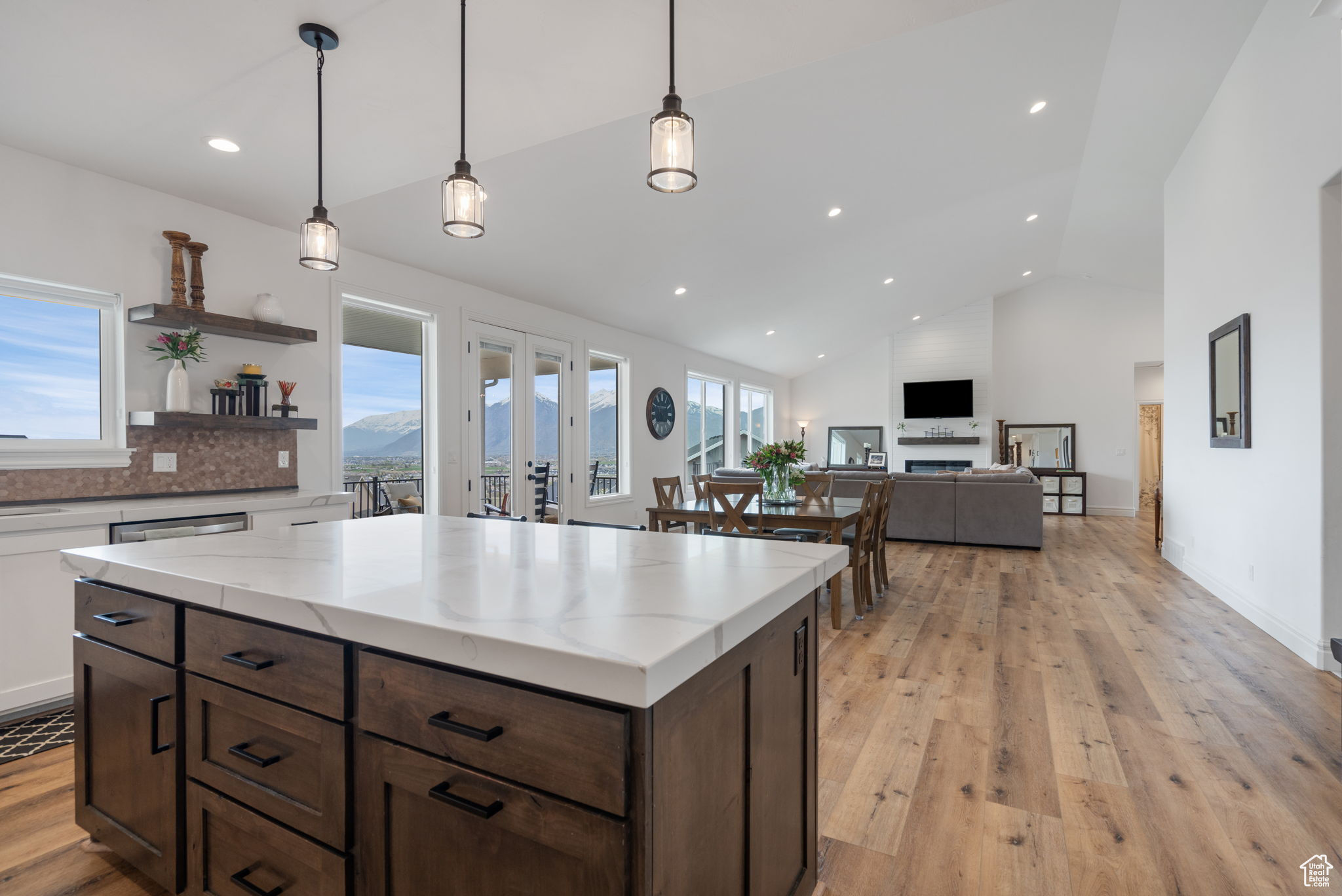 Kitchen featuring backsplash, a healthy amount of sunlight, light hardwood / wood-style floors, and hanging light fixtures