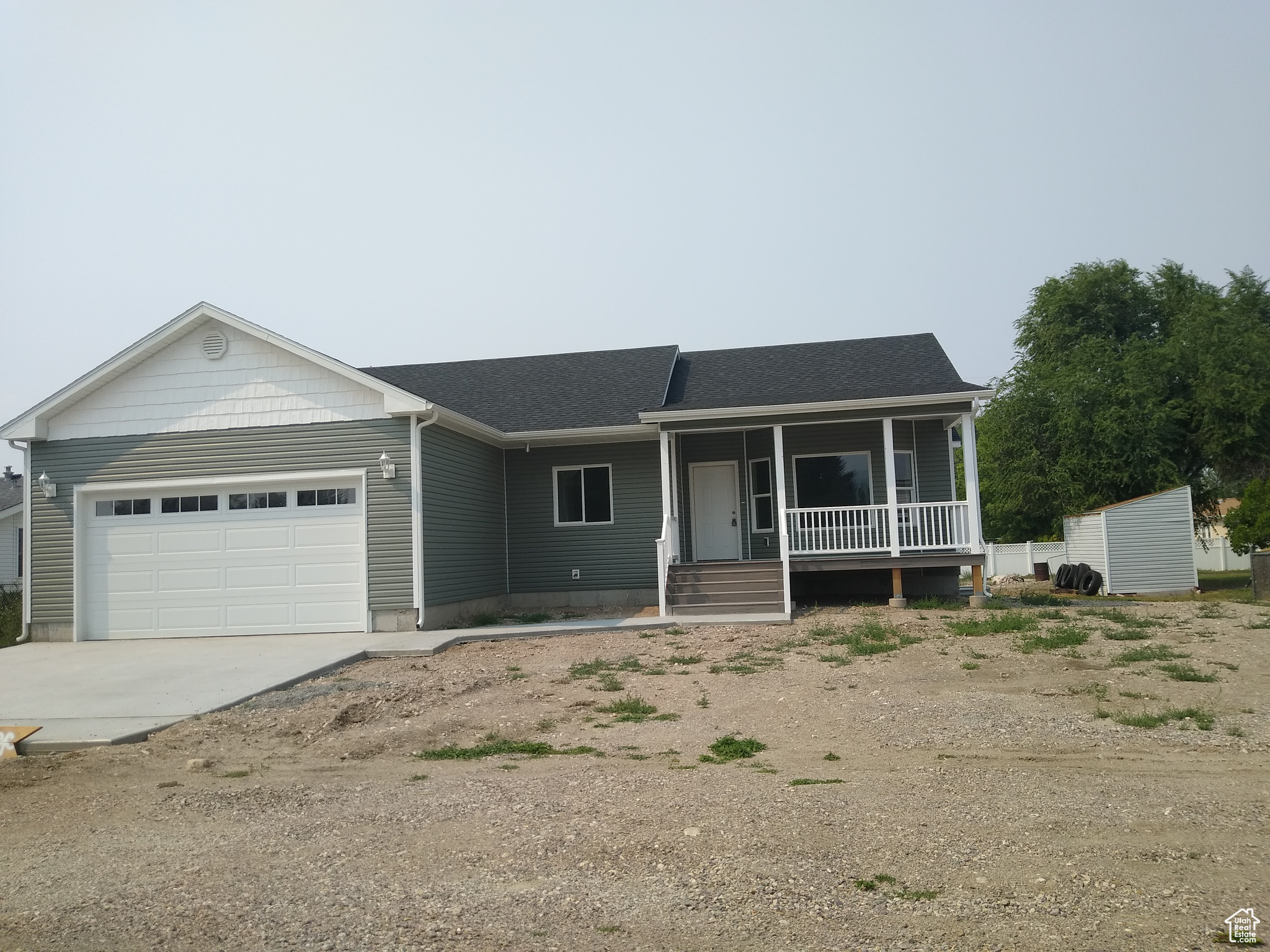 Ranch-style house featuring a garage and a porch