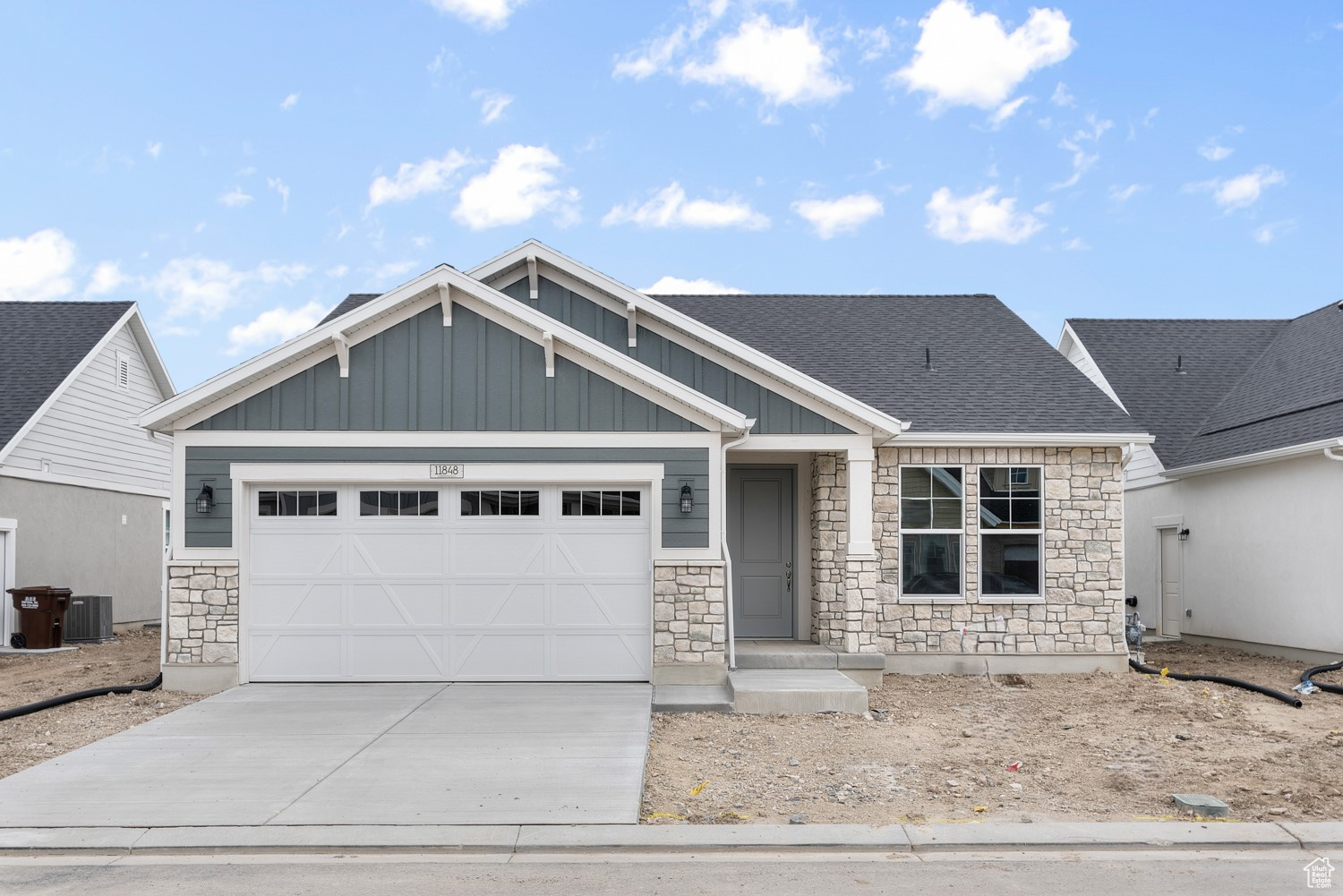 Craftsman inspired home with a garage and central air condition unit