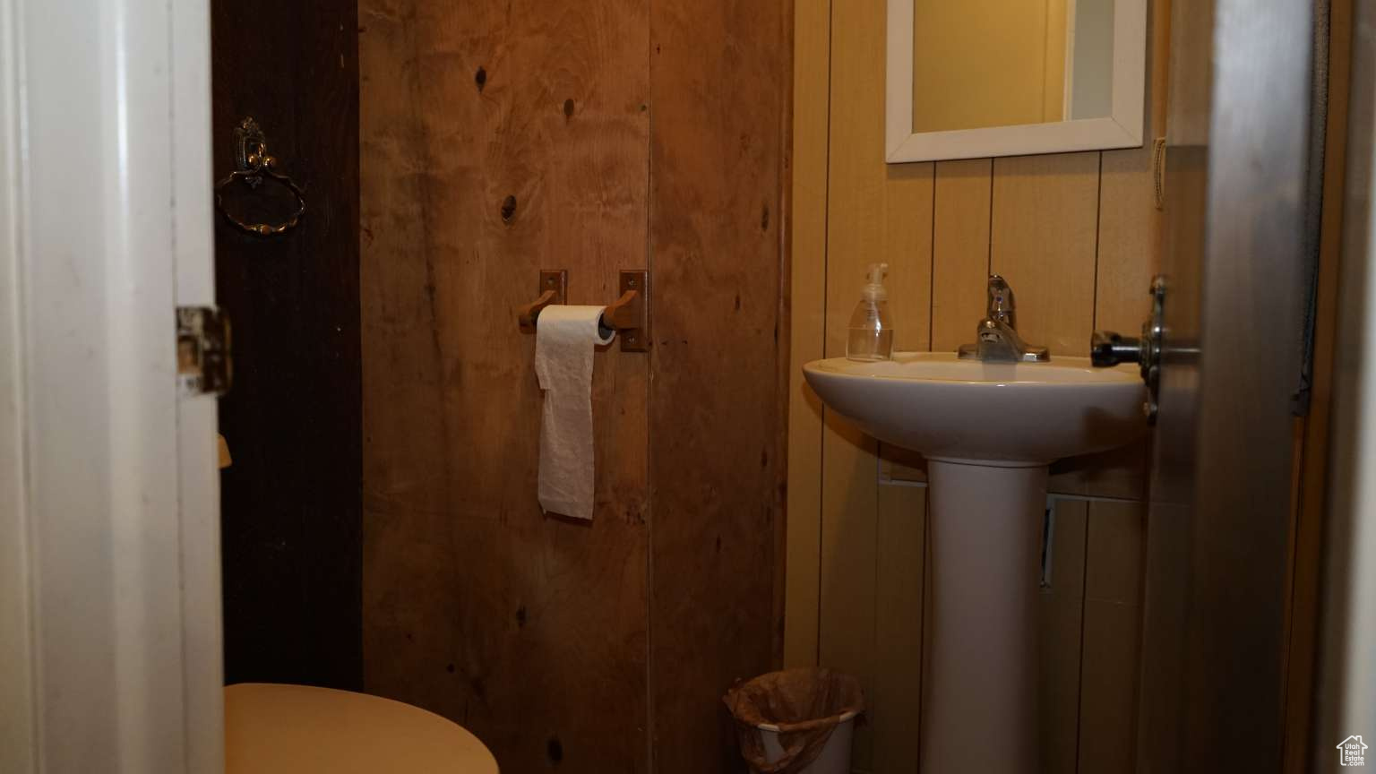Bathroom featuring wood walls and toilet