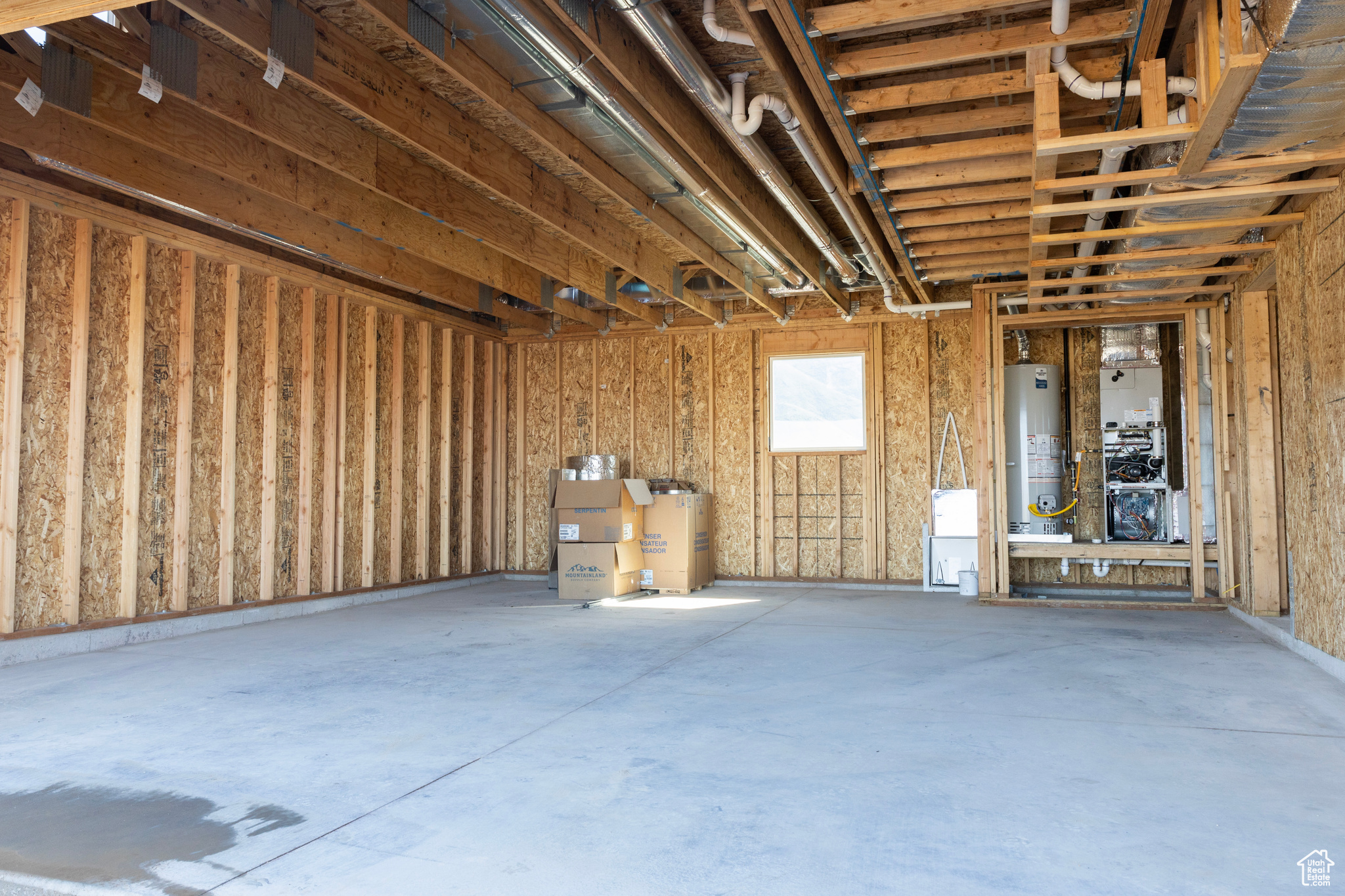 Garage featuring water heater and concrete floors