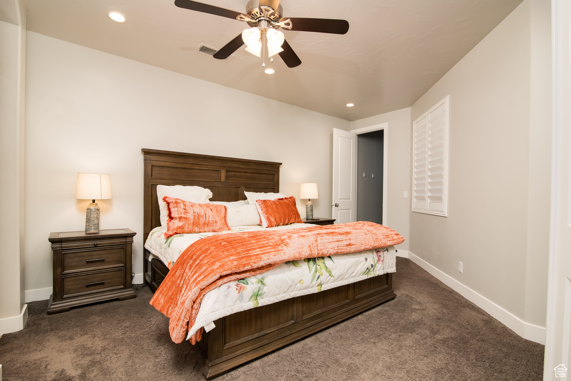 Carpeted bedroom with ceiling fan with ensuite bathroom