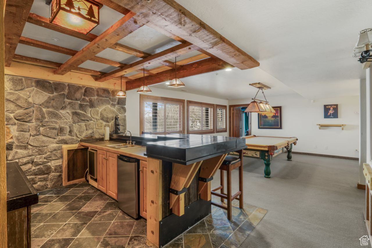 Kitchen featuring beamed ceiling, a kitchen bar, sink, dishwasher, and pool table