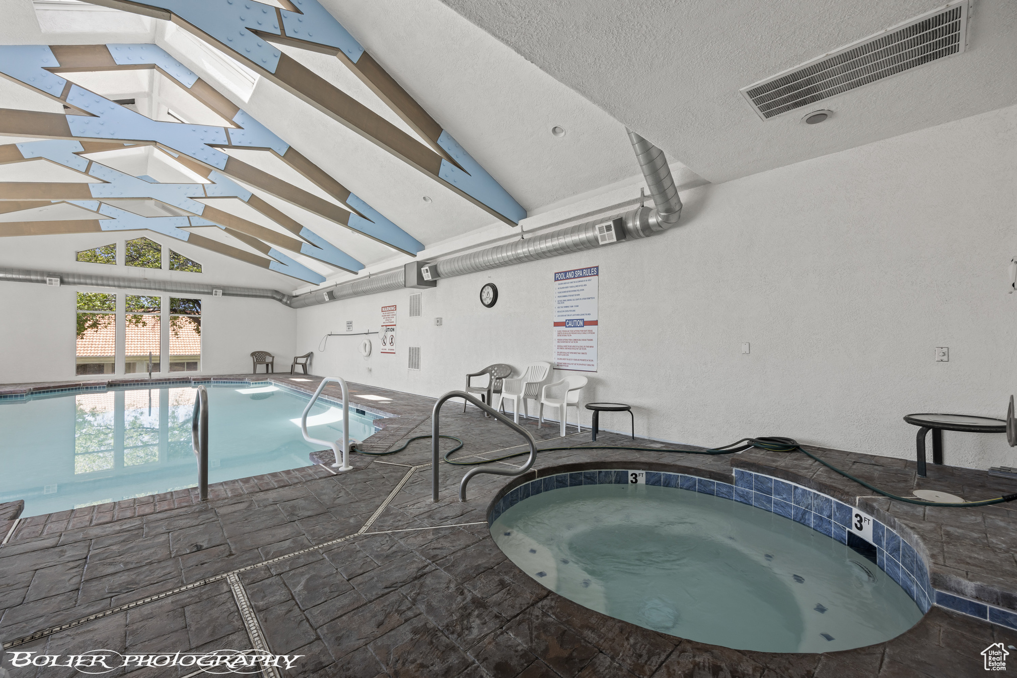 View of pool featuring a skylight and an indoor hot tub