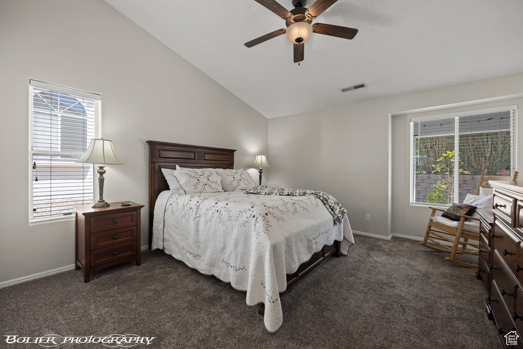 Spacious master bedroom featuring lofted ceiling and ceiling fan