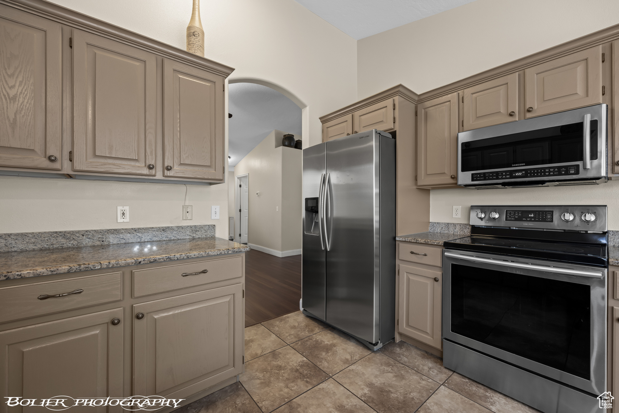 Kitchen featuring appliances with stainless steel finishes, light tile floors, and granite countertops