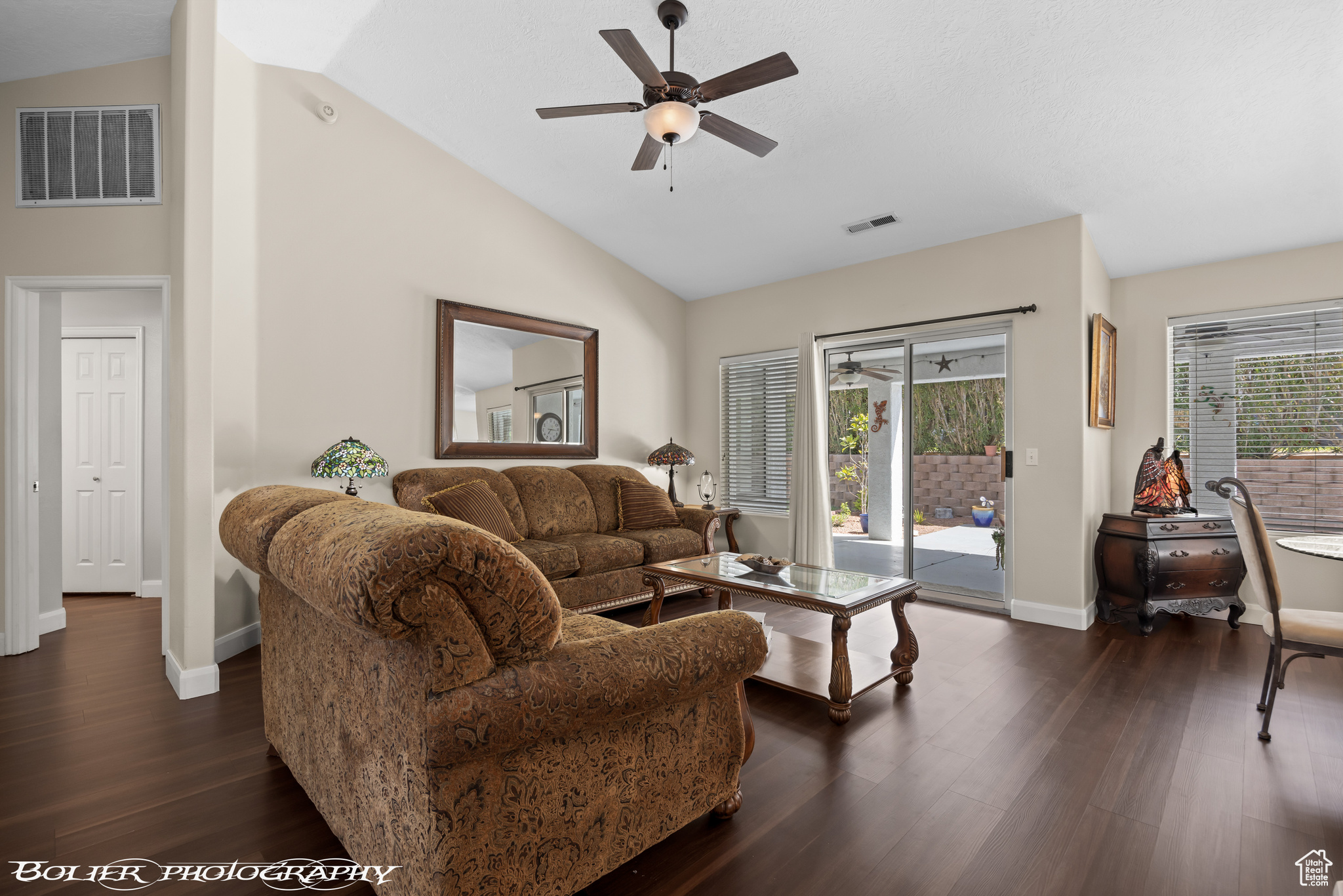 Living room featuring dark hardwood / wood-style floors, high vaulted ceiling, ceiling fan, and plenty of natural light