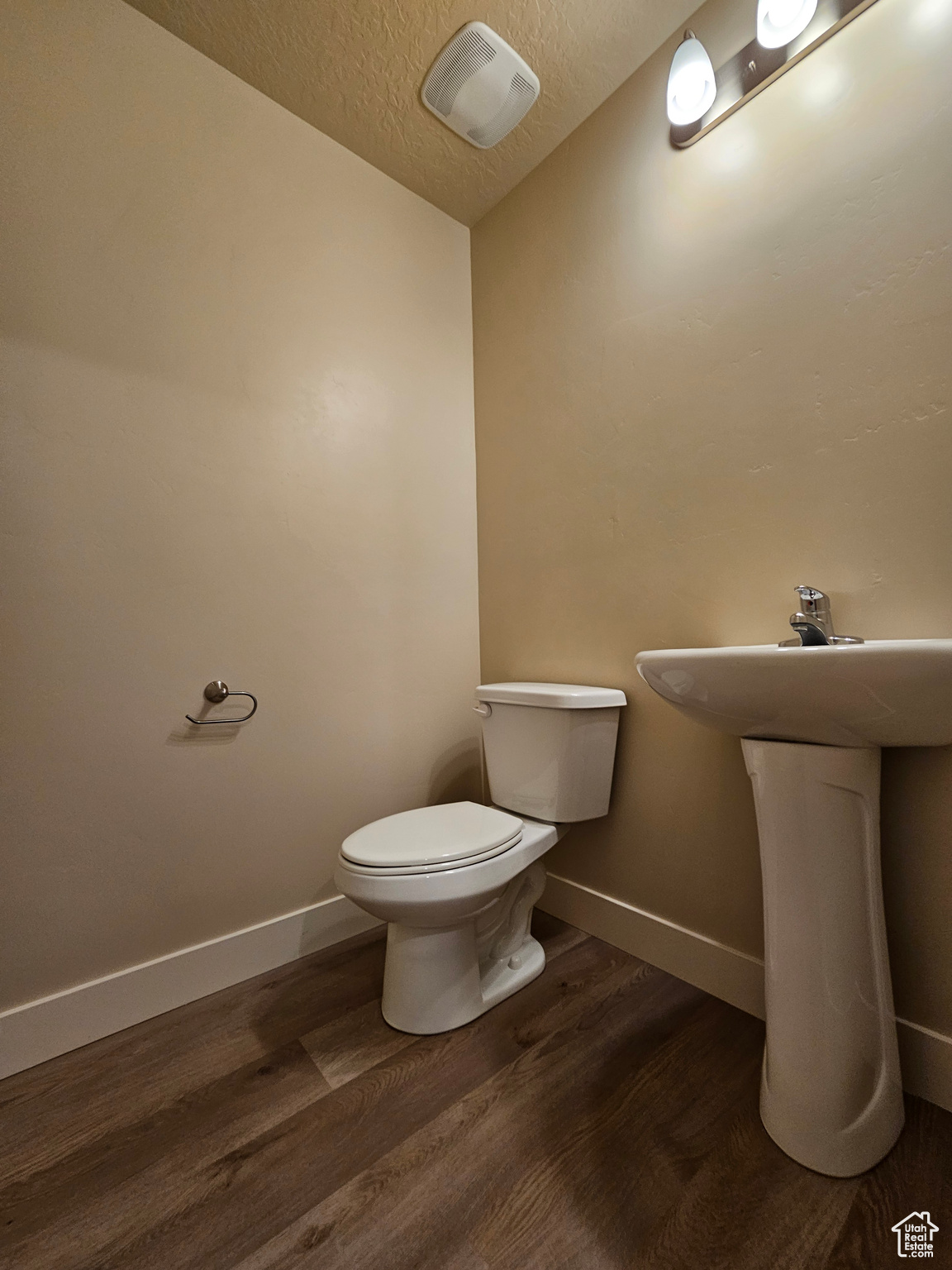 Bathroom featuring a textured ceiling, toilet, and hardwood / wood-style floors