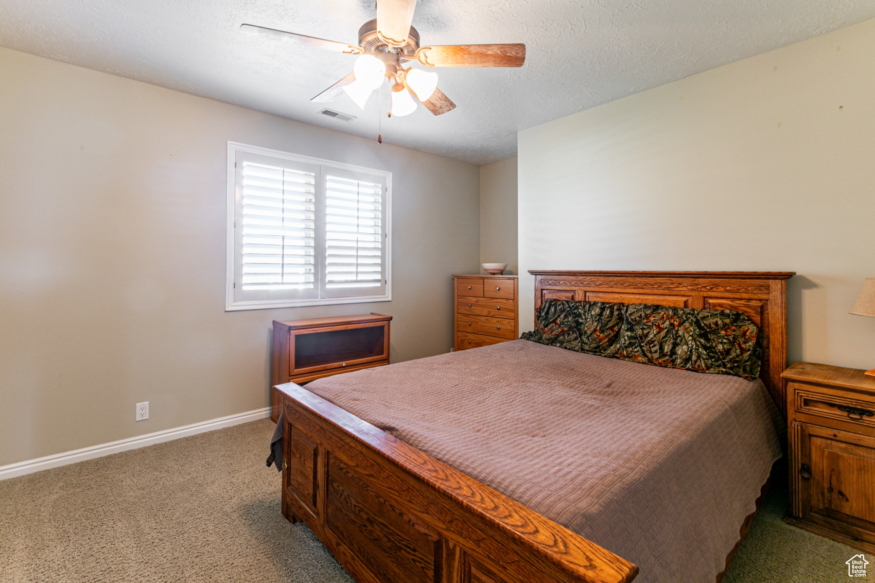 Bedroom featuring ceiling fan, carpet floors, and a textured ceiling