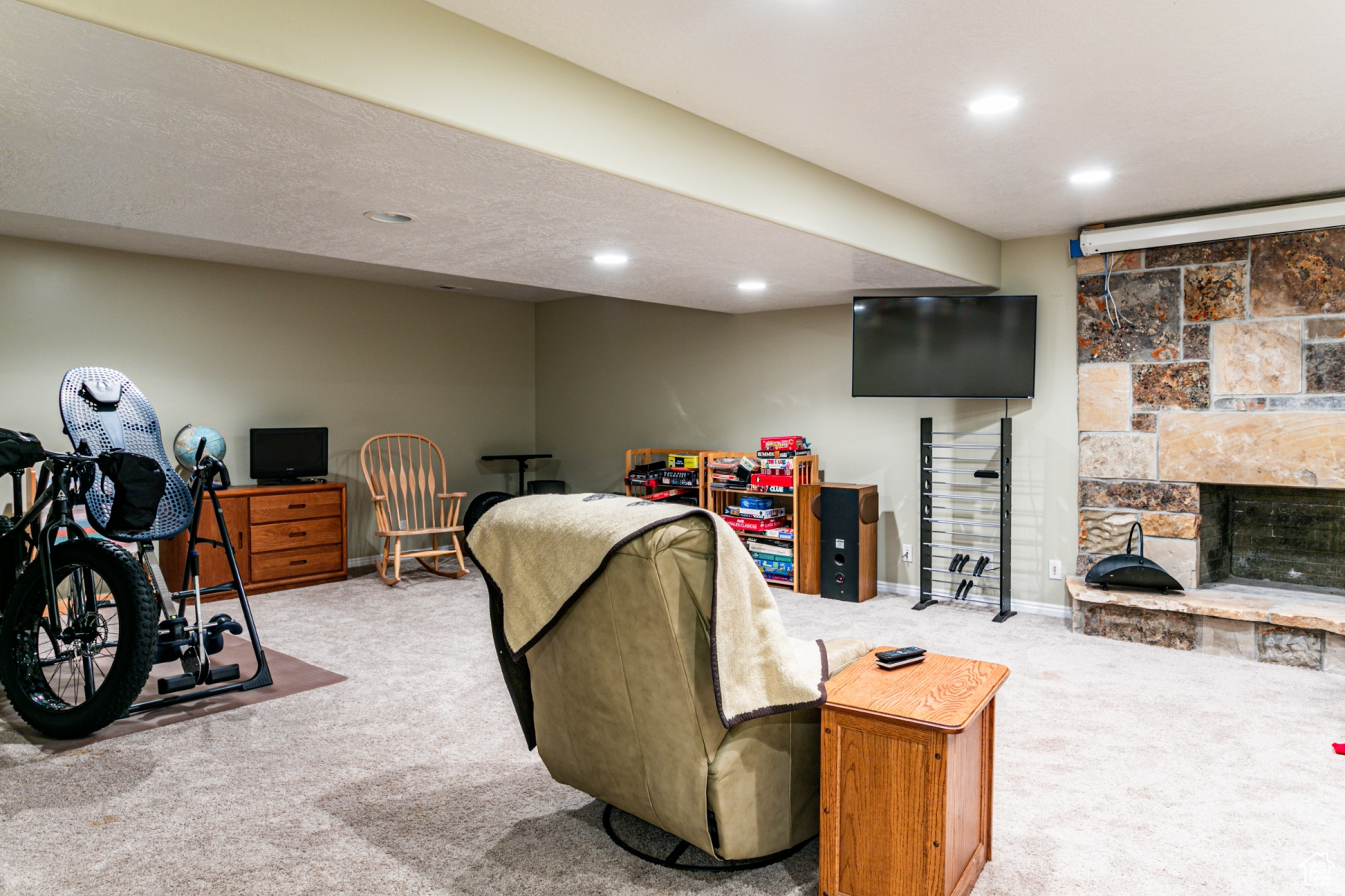 Carpeted living room featuring a fireplace in the basement
