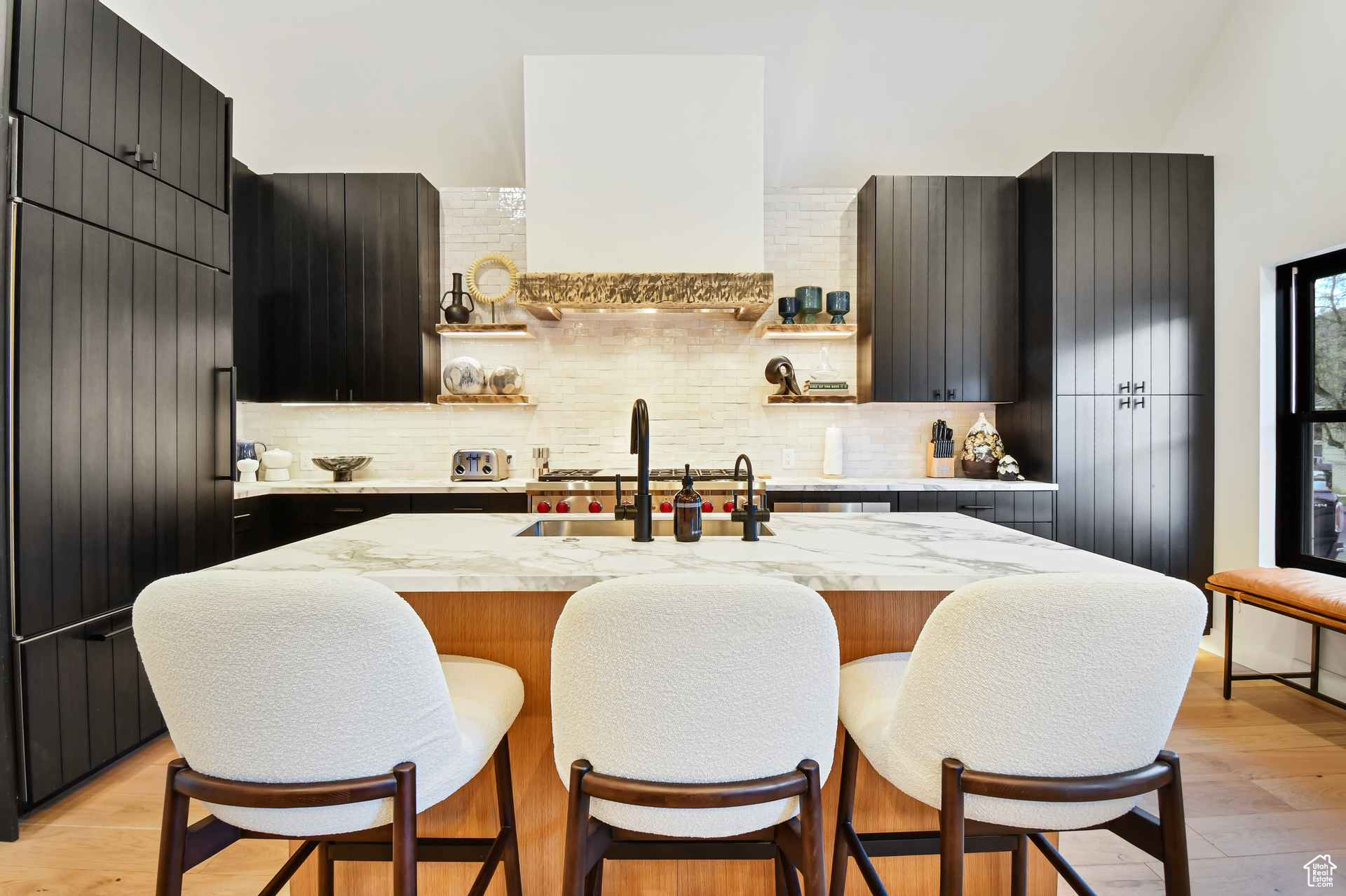 Kitchen featuring a breakfast bar area, light hardwood / wood-style flooring, tasteful backsplash, and sink