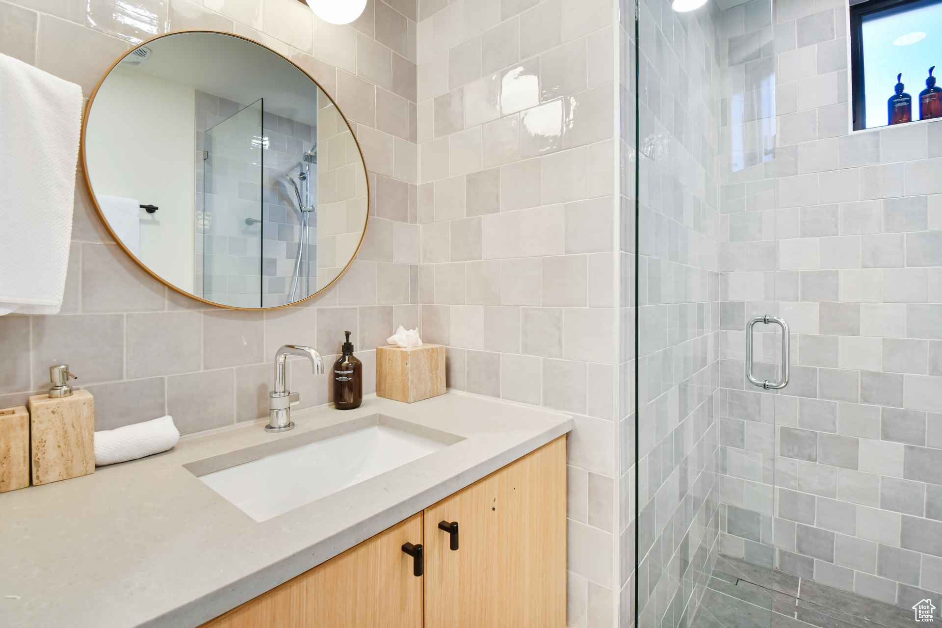Bathroom featuring tile walls, tasteful backsplash, an enclosed shower, and vanity