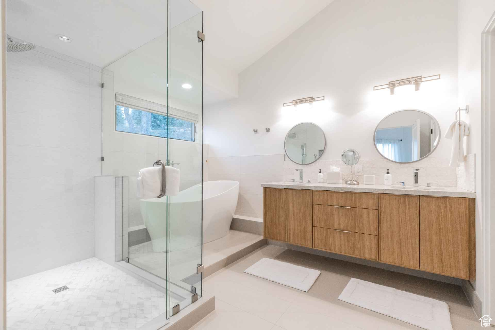 Bathroom with tile floors, tile walls, separate shower and tub, dual vanity, and tasteful backsplash