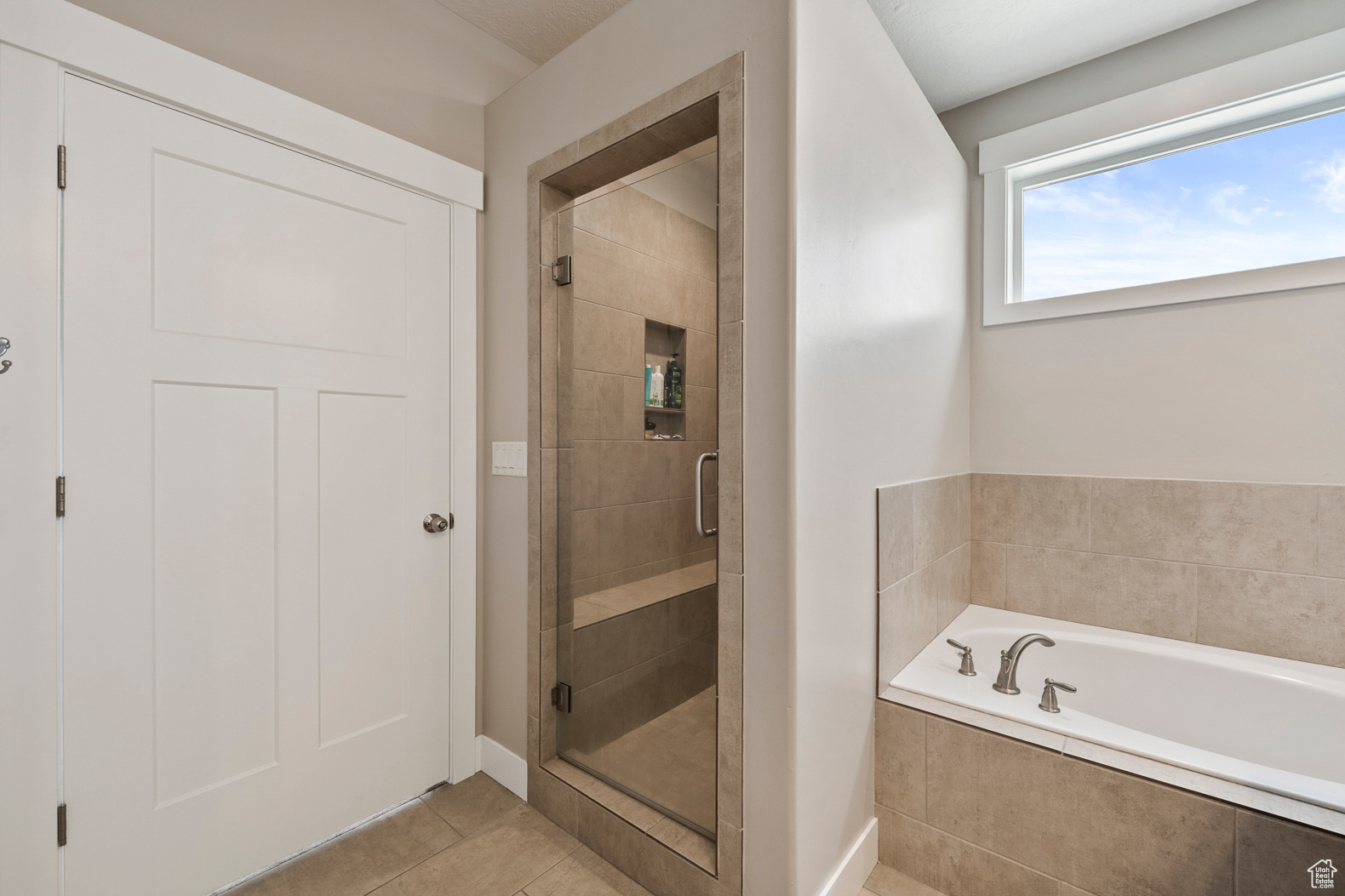 Bathroom featuring tile floors and plus walk in shower