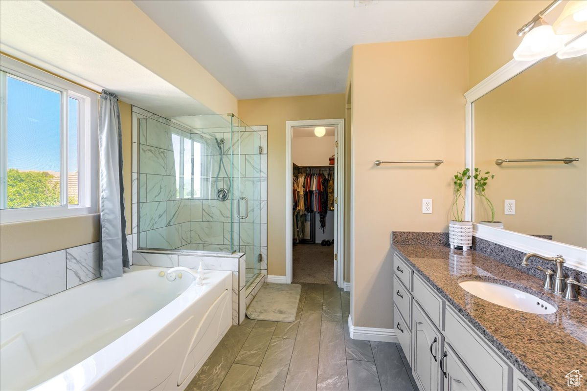 Bathroom featuring large vanity, tile floors, and separate shower and tub