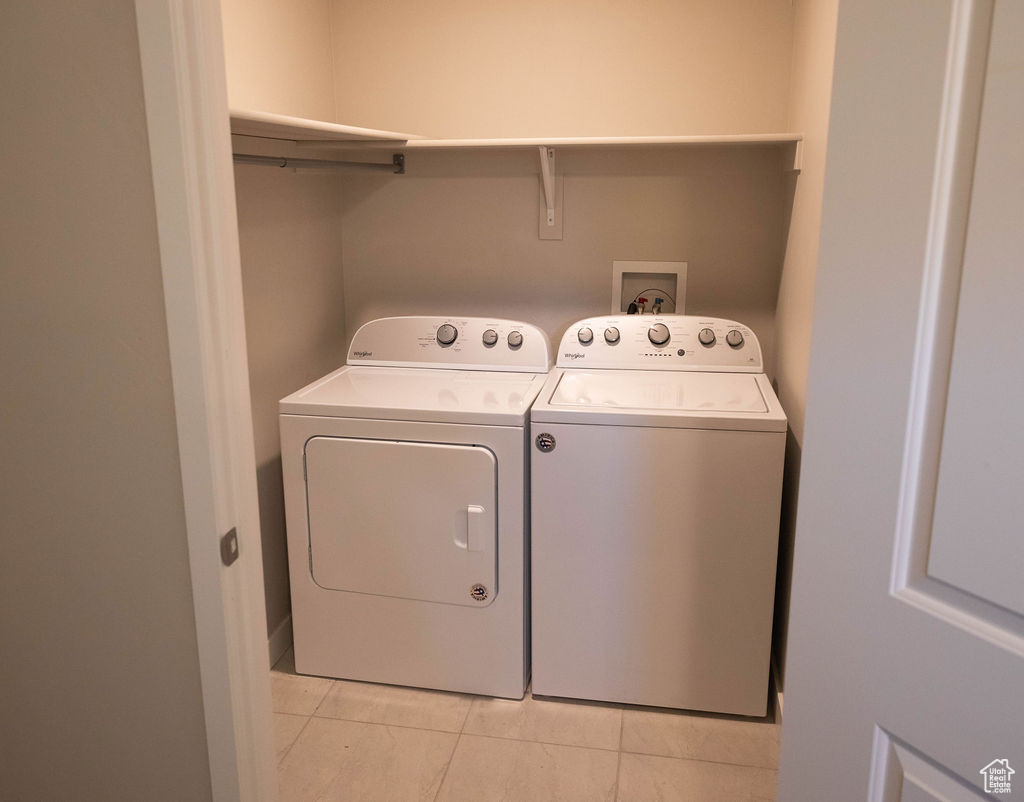 Laundry area with light tile floors, washer and dryer